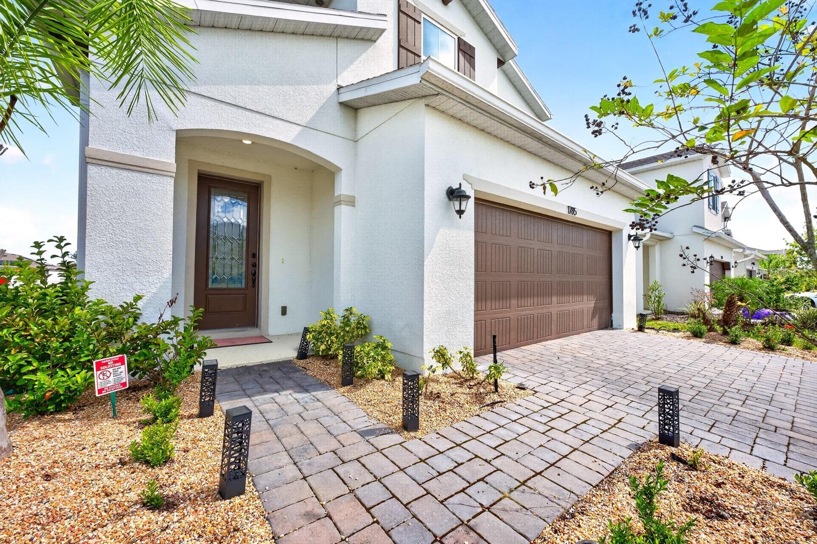 A BRICK PAVER DRIVEWAY leads to the TWO-CAR GARAGE, while a matching paver walkway welcomes you to the front porch. - 1785 PETIOLE PL, KISSIMMEE