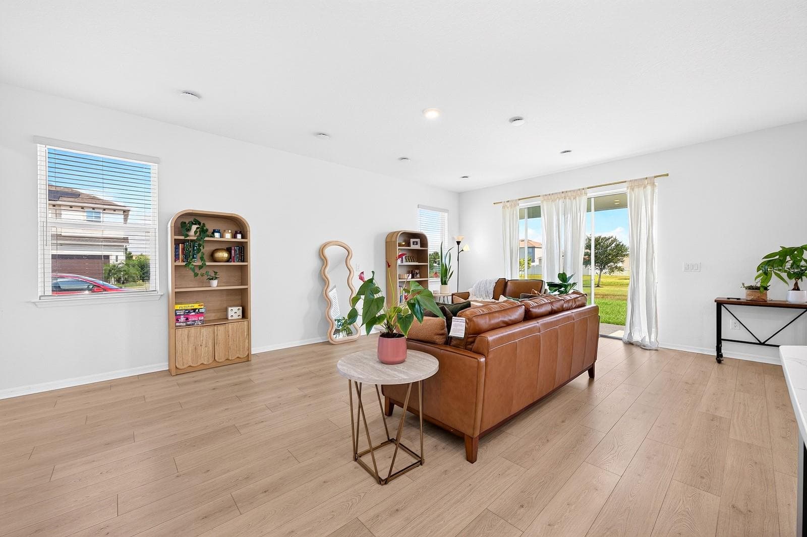 NATURAL LIGHT pours in through the windows and sliding glass door, enhancing the home's warm, airy feel. - 1785 PETIOLE PL, KISSIMMEE