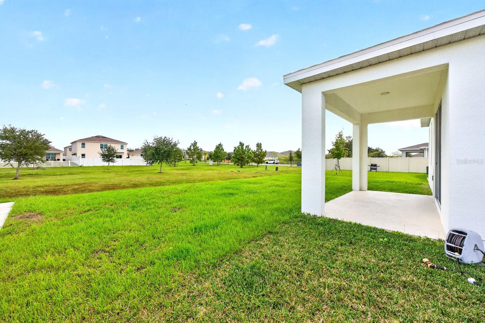 Step outside to the COVERED REAR PORCH overlooking the GENEROUS BACKYARD. - 1785 PETIOLE PL, KISSIMMEE