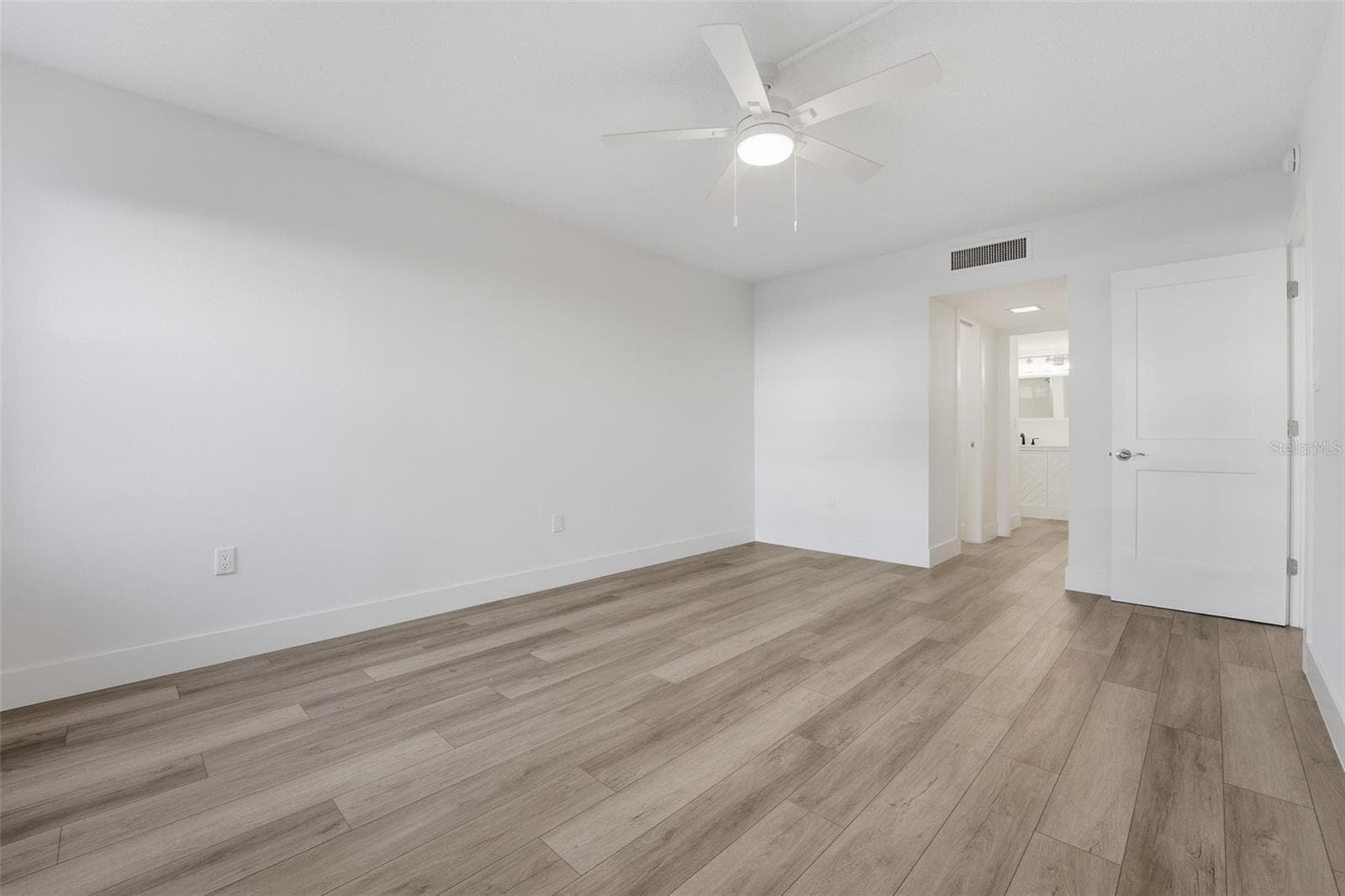 Primary Bedroom looking to hallway to bathroom - 1150 TARPON CENTER DR #101, 1-A, VENICE