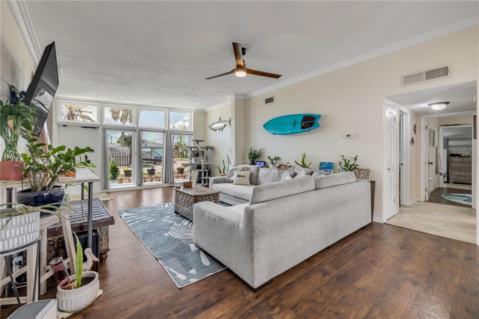 Living area with wood flooring and views toward the front windows. - 3929 S PENINSULA DR, PORT ORANGE