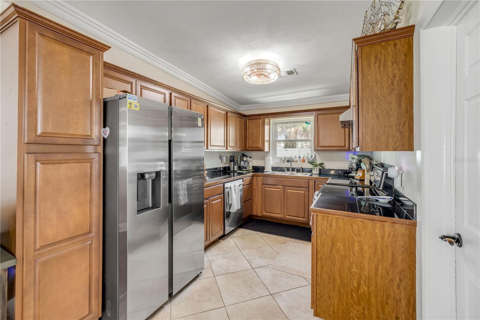 Kitchen with wood cabinetry and stainless-steel appliances. - 3929 S PENINSULA DR, PORT ORANGE
