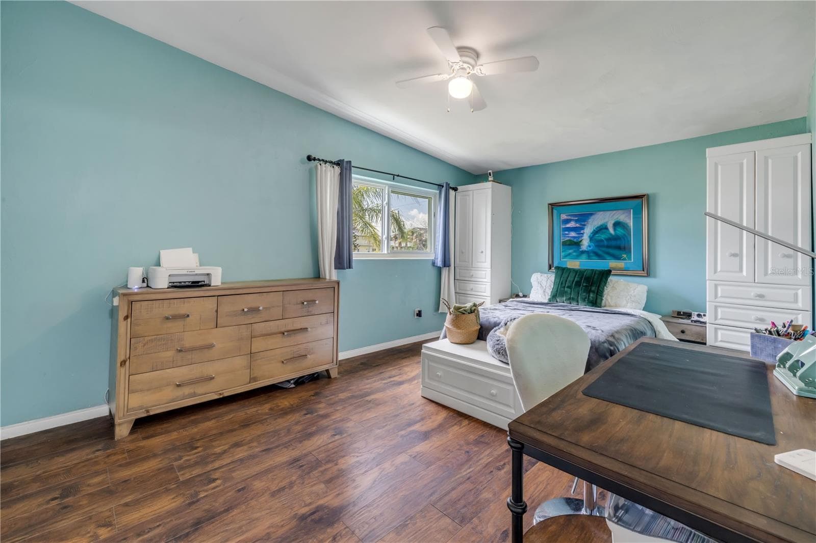 Bedroom with windows, ceiling fan and coastal-blue walls. - 3929 S PENINSULA DR, PORT ORANGE
