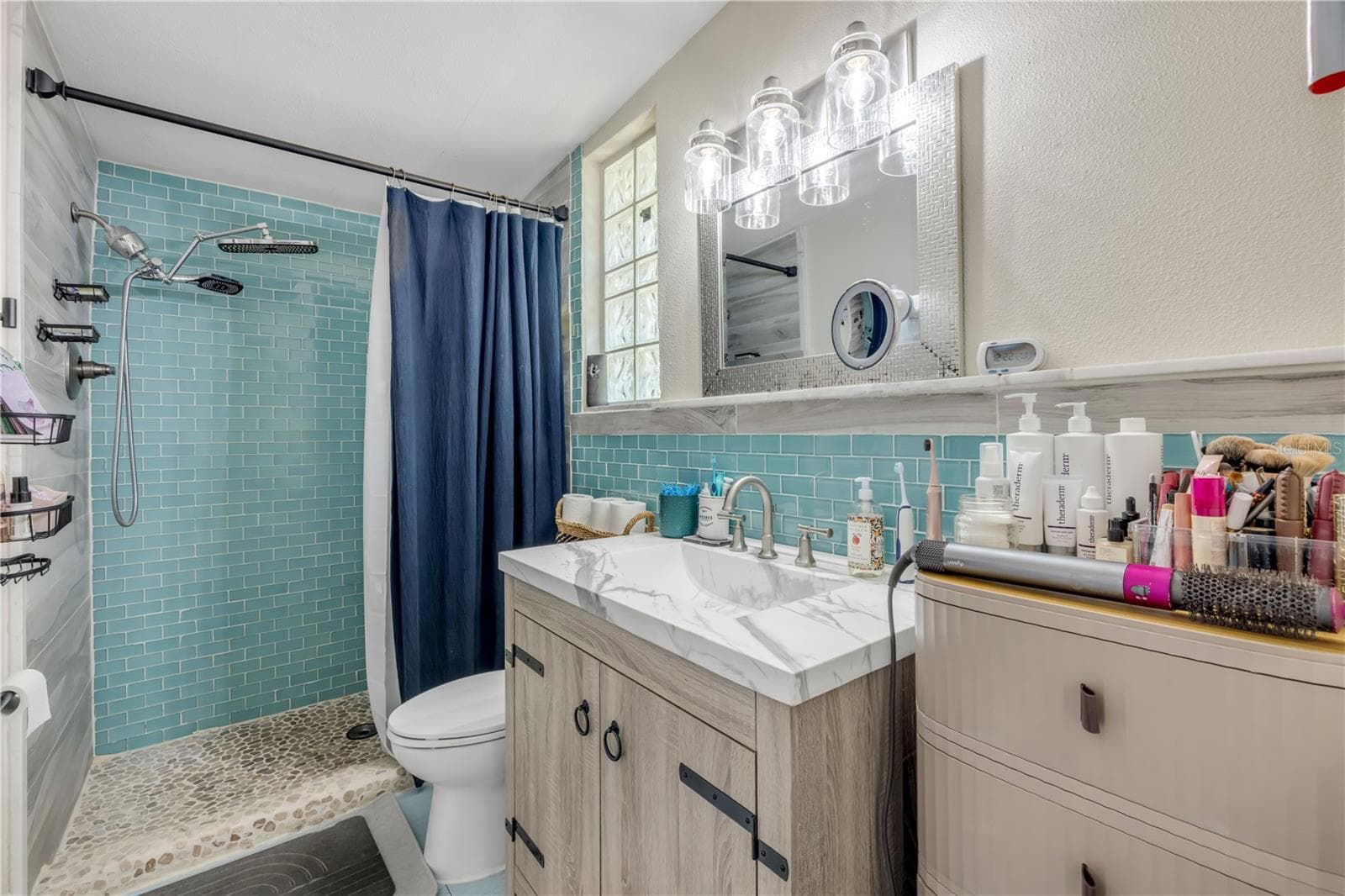 Bathroom with double-sink vanity and a glass-enclosed shower. - 3929 S PENINSULA DR, PORT ORANGE
