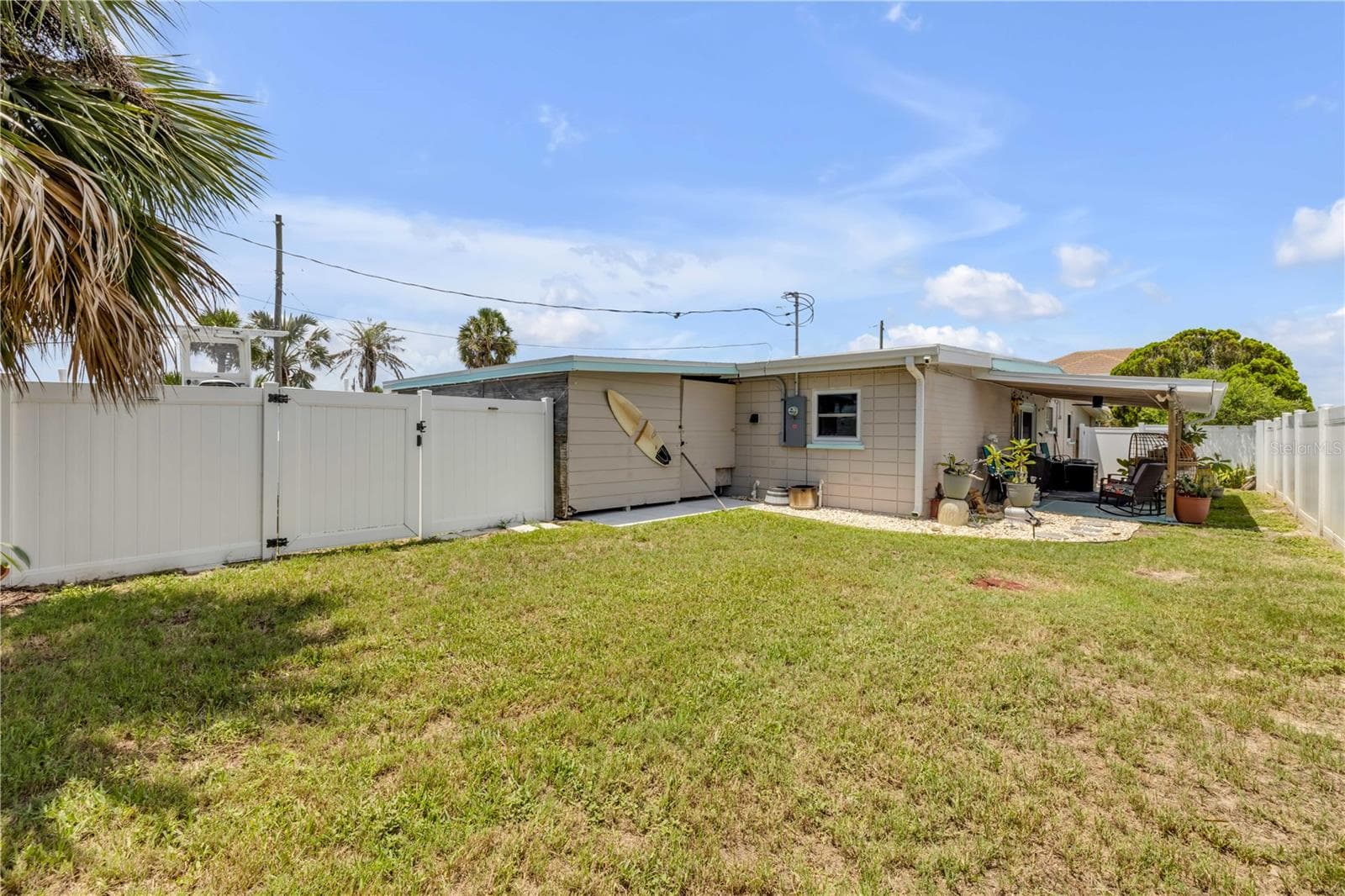 Rear exterior and fenced lawn. - 3929 S PENINSULA DR, PORT ORANGE