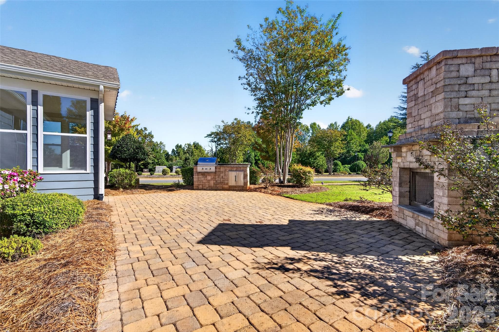 Custom paver rear patio with built-in fireplace and grill - 8905 Silver Springs Court, Charlotte
