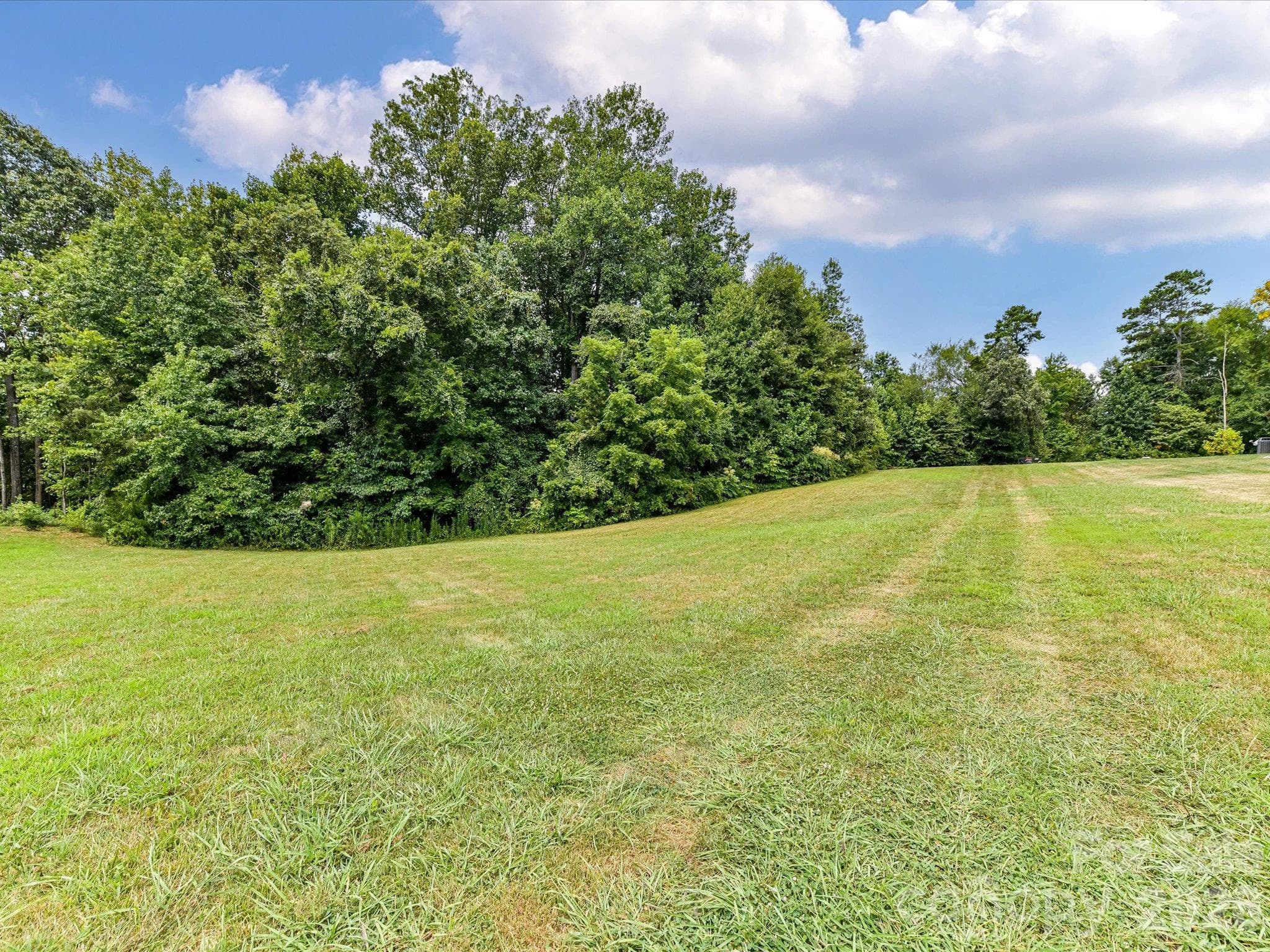 Expansive, level homesite featuring lush green space, scenic surroundings, and beautiful views of neighboring custom homes, offering an ideal setting to build your dream home. - Lot 15 Peacehaven Place, Statesville