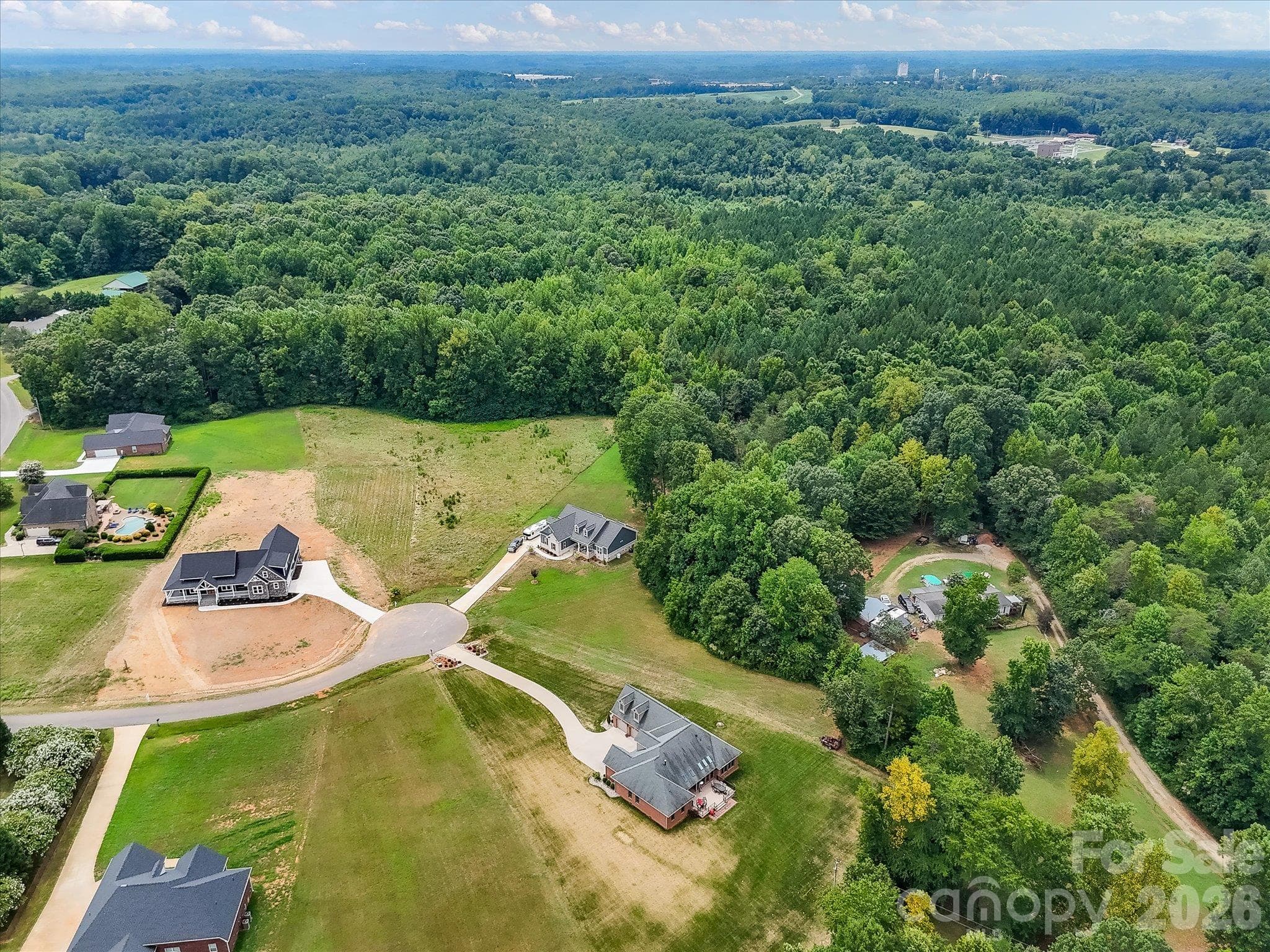 Beautiful aerial perspective showcasing a peaceful residential community with spacious homesites, attractive custom homes, quiet cul-de-sac streets, and expansive wooded surroundings offering a serene countryside setting. - Lot 15 Peacehaven Place, Statesville