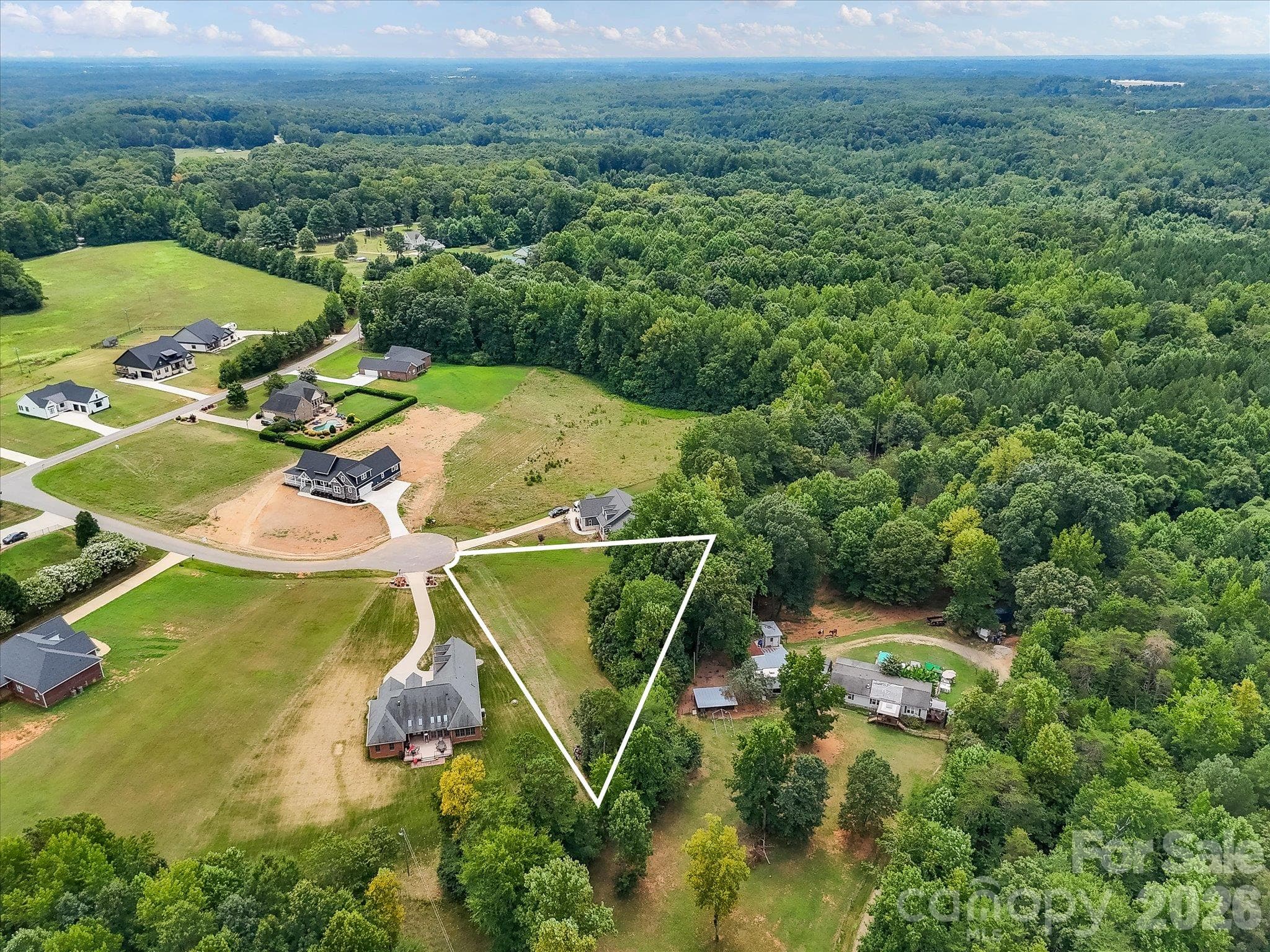 Expansive aerial view showcasing a peaceful cul-de-sac community with spacious homesites, beautiful custom homes, and lush wooded surroundings offering privacy and picturesque countryside scenery. - Lot 15 Peacehaven Place, Statesville