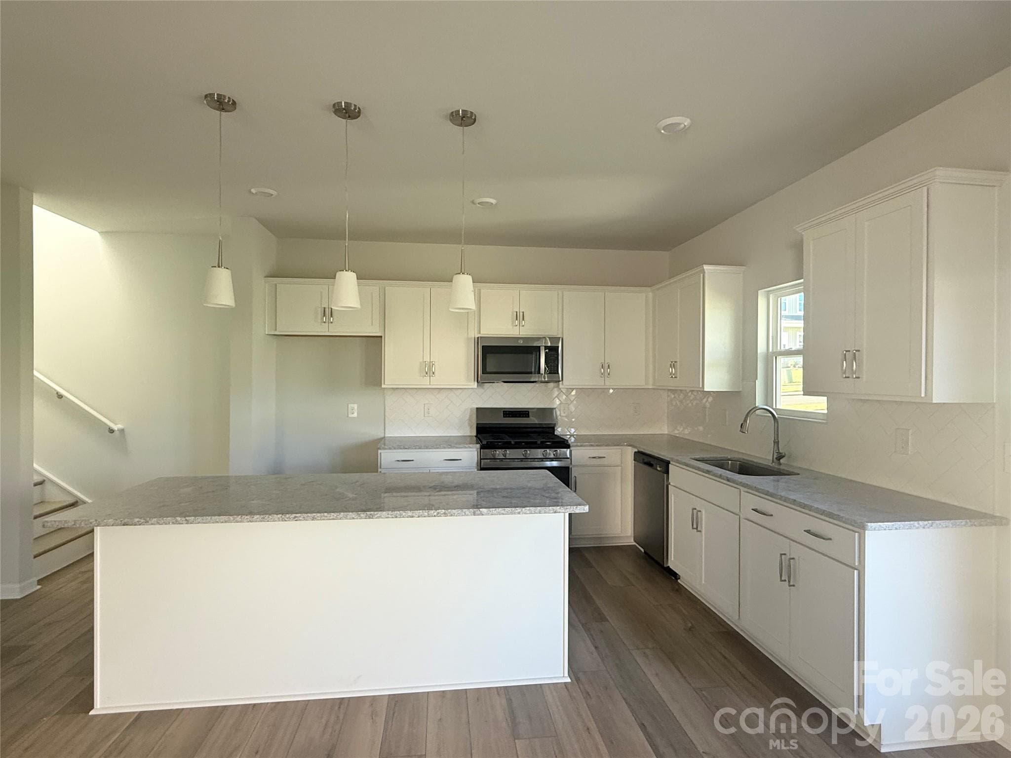 Kitchen features white cabinets and granite countertops - 1227 Bansal Drive, Charlotte