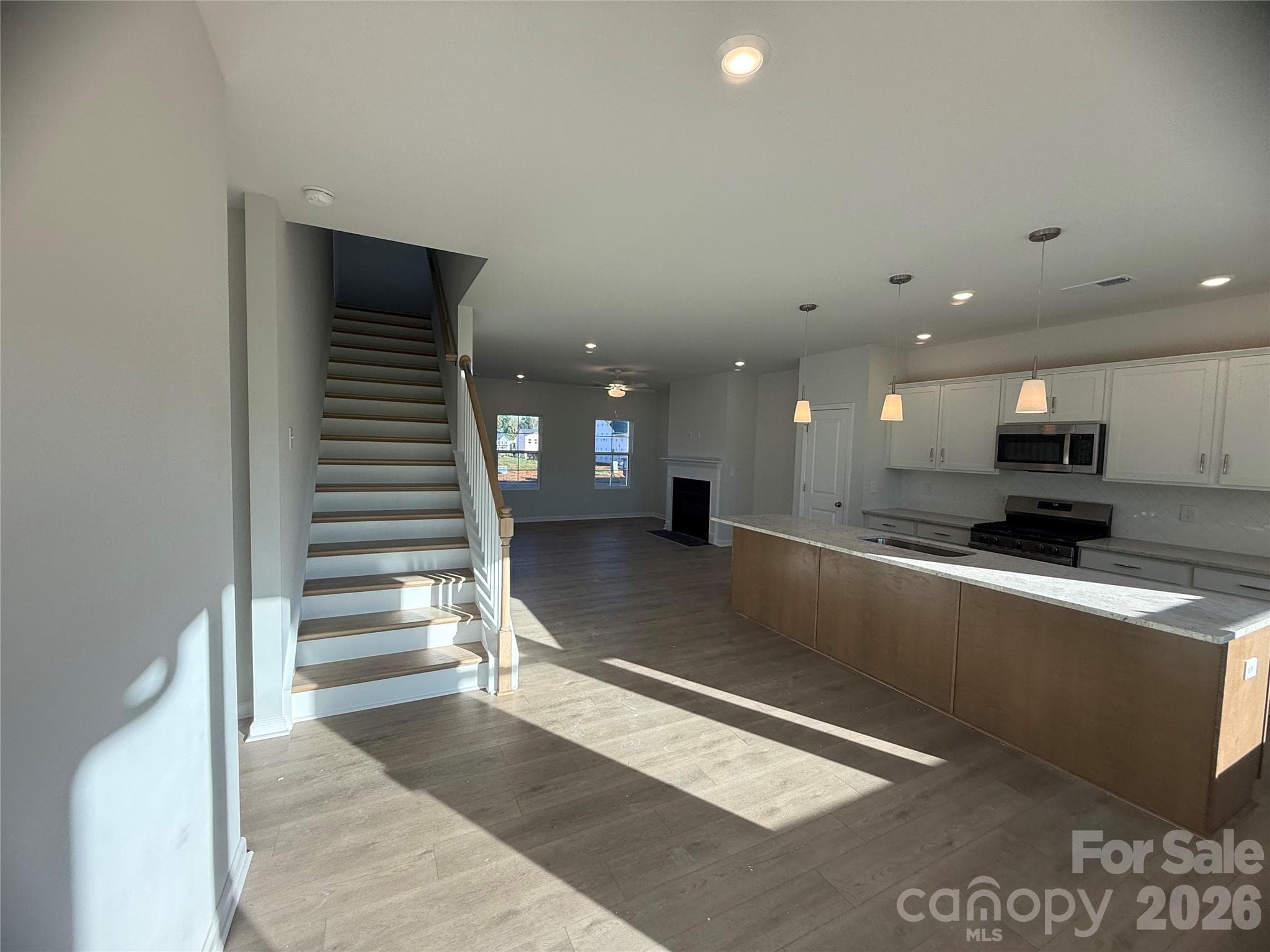 Kitchen features white surround cabinets and brown island with granite countertops - 4021 Juno Drive, Charlotte