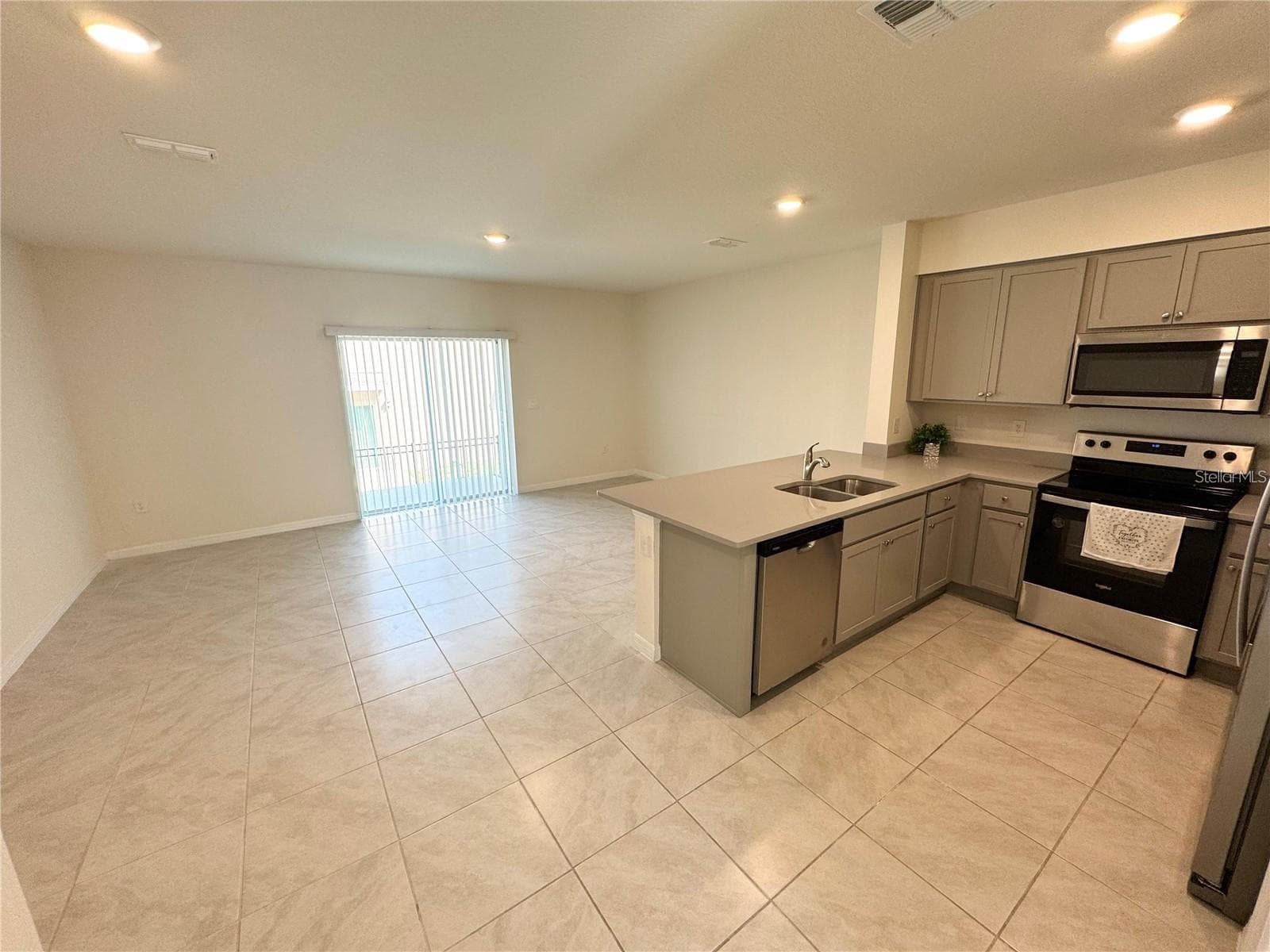 View of living room, sliding doors, dining area and kitchen. - 2353 PENGUIN BLVD, DAVENPORT