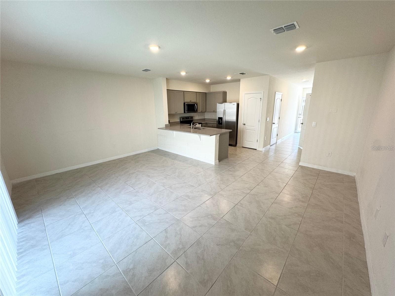 View of living room, dining room combo toward breeze way and entrance. - 2353 PENGUIN BLVD, DAVENPORT