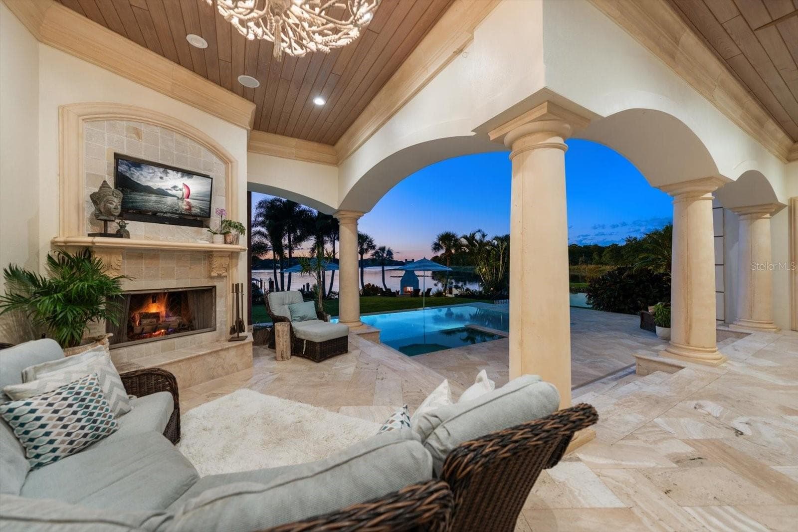 An expansive covered lanai offers inviting seating, a wood-and-gas fireplace and an Alfresco outdoor kitchen - 2056 COVE TRCE, PALM HARBOR