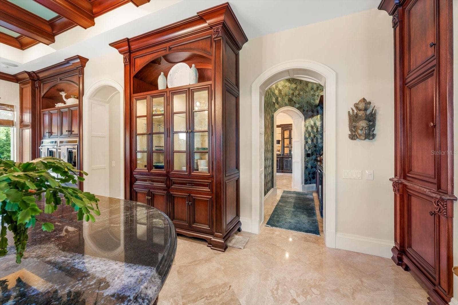 Arched doorways and a walk-through wet bar connecting to the formal dining room - 2056 COVE TRCE, PALM HARBOR