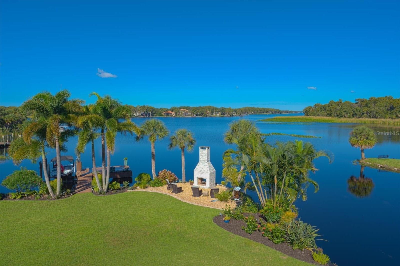 Unbelievable Views! The romantic see-through wood-burning fireplace adds ambiance to the waterfront setting - 2056 COVE TRCE, PALM HARBOR
