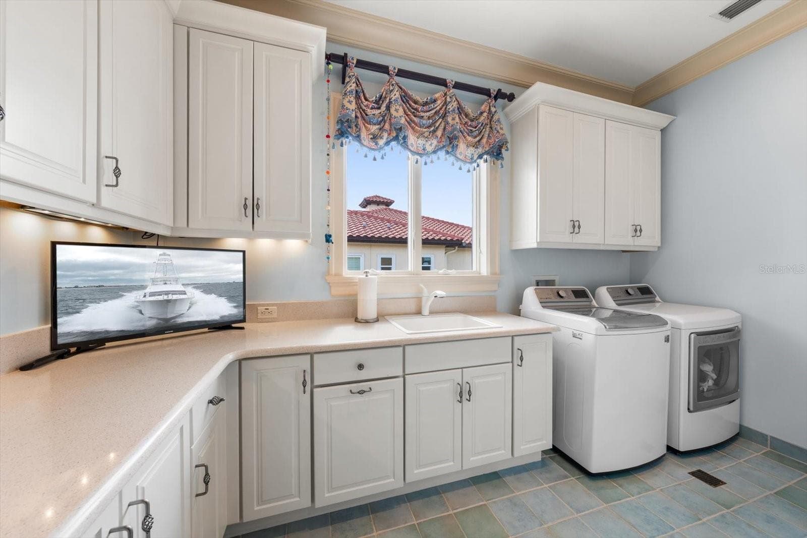 Oversized Laundry Room with stairs leading to attic space for even more storage! - 2056 COVE TRCE, PALM HARBOR