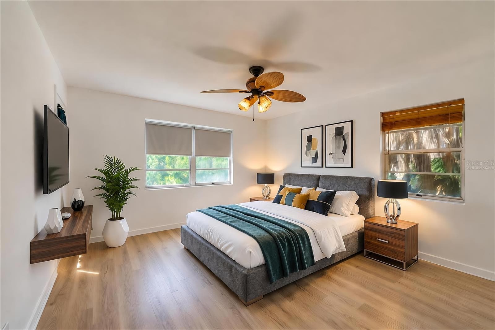Virtually Staged - Generous interior room featuring light LVP flooring, crisp white walls, and a woven palm leaf ceiling fan. Multiple windows fill the space with natural light. - 128 MINERVA RD, DAYTONA BEACH