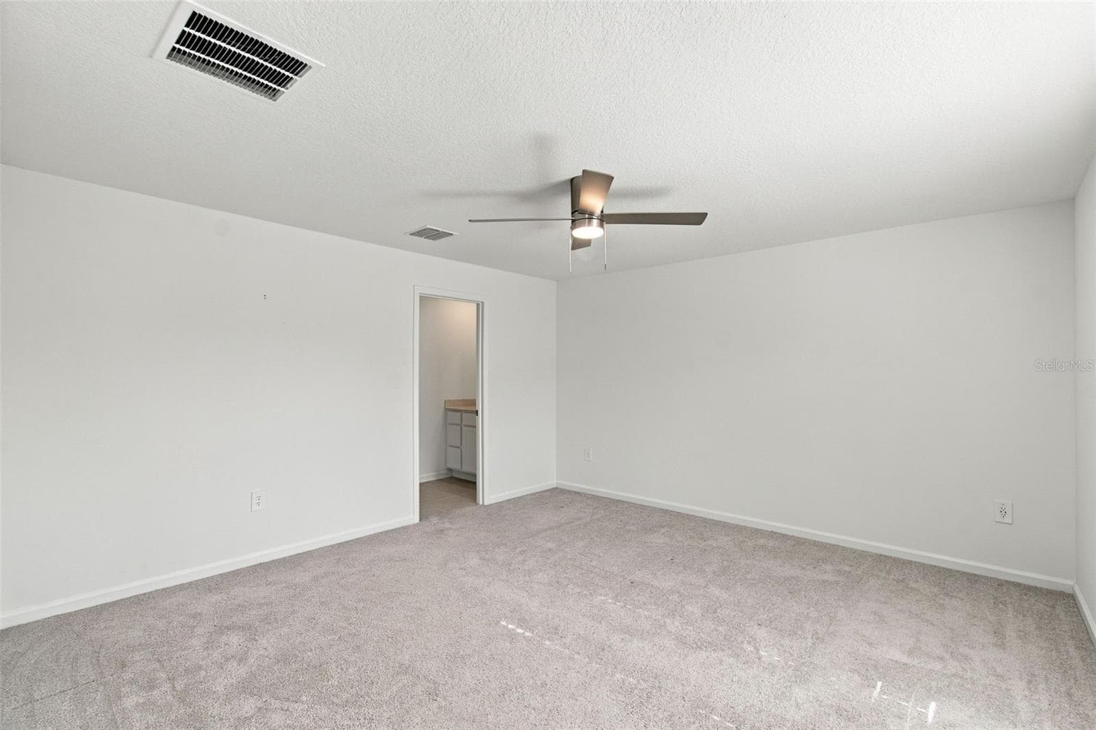 The private owner’s suite is tucked away at the back of the home and features an en-suite bathroom with dual sinks, a walk-in shower, and a generous walk-in closet. - 2007 FORAGE DR, KISSIMMEE