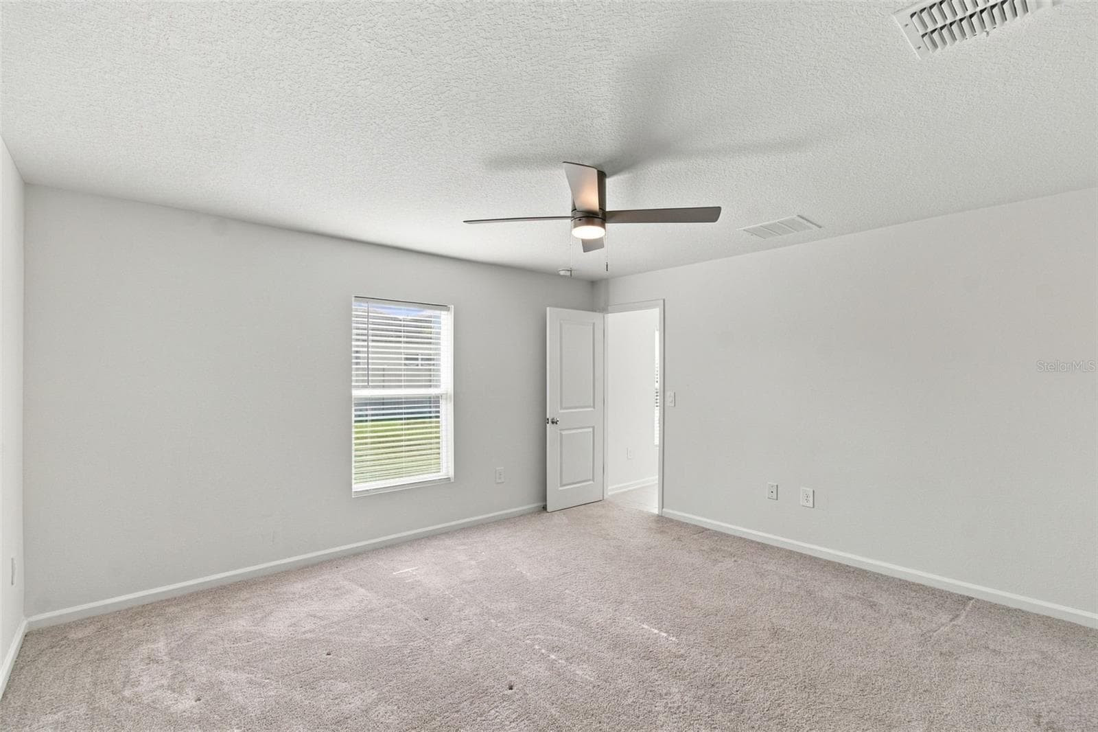The private owner’s suite is tucked away at the back of the home and features an en-suite bathroom with dual sinks, a walk-in shower, and a generous walk-in closet. - 2007 FORAGE DR, KISSIMMEE