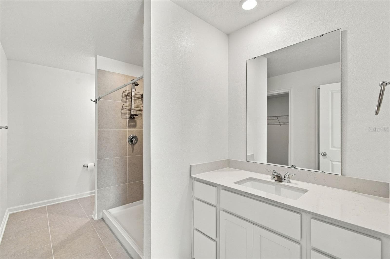 The private owner’s suite is tucked away at the back of the home and features an en-suite bathroom with dual sinks, a walk-in shower, and a generous walk-in closet. - 2007 FORAGE DR, KISSIMMEE