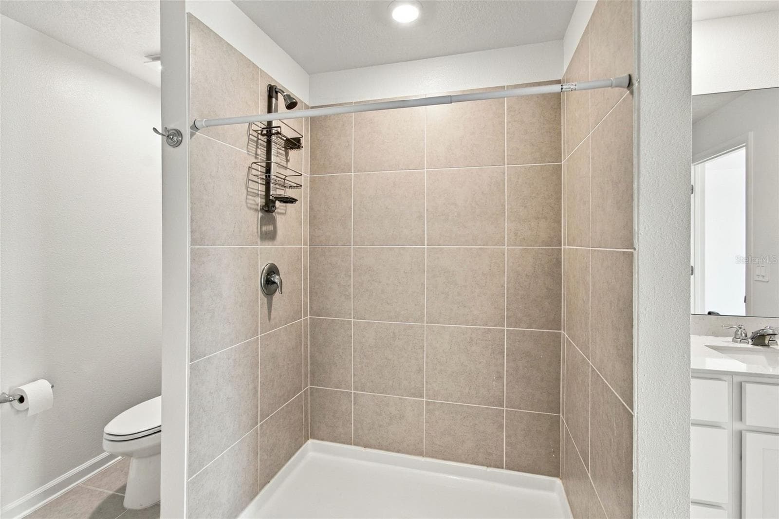 The private owner’s suite is tucked away at the back of the home and features an en-suite bathroom with dual sinks, a walk-in shower, and a generous walk-in closet. - 2007 FORAGE DR, KISSIMMEE