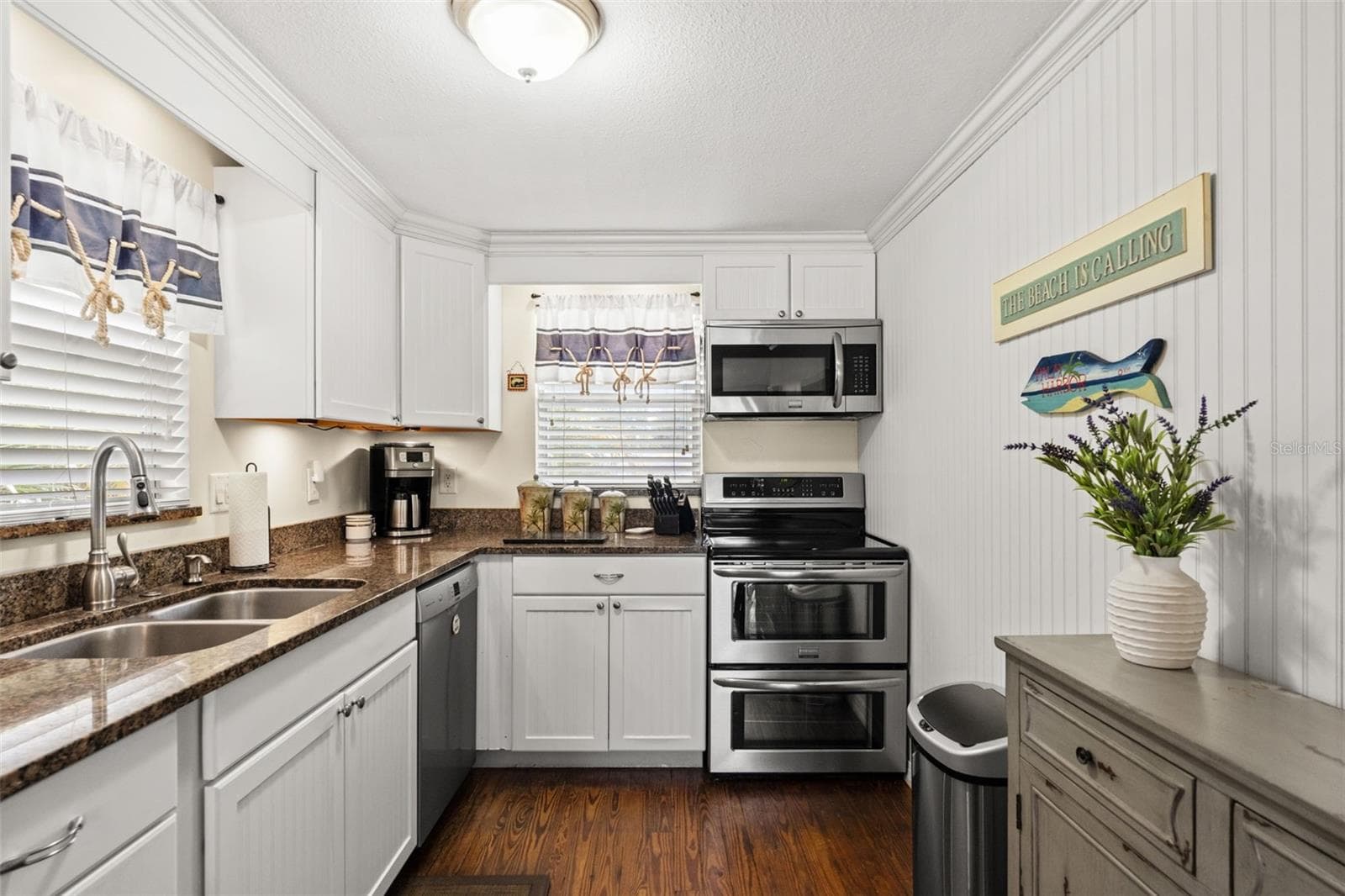 Thoughtfully arranged for everyday convenience, the kitchen features a double-basin sink, stainless steel dishwasher, electric range with double ovens, built-in microwave, and ample cabinetry. Windows bring natural light into the space. - 13 FRESHWATER, PALM HARBOR