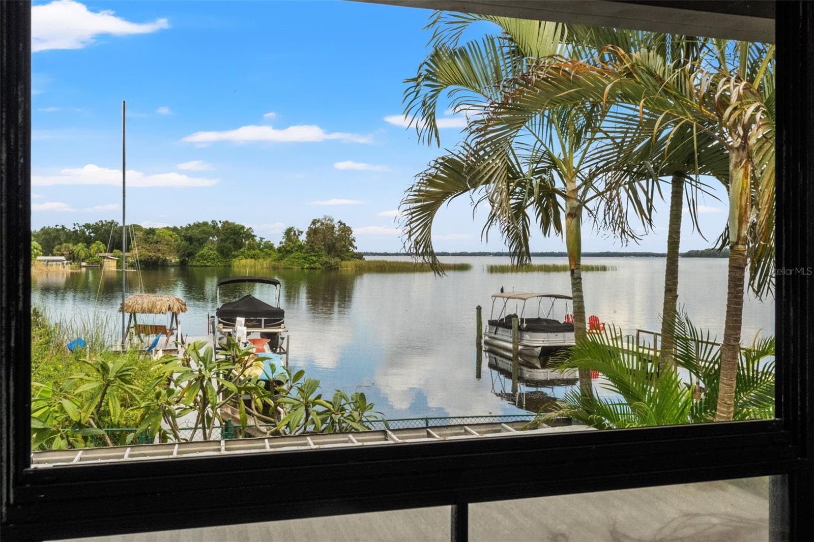 This is what Florida waterfront living is all about! Enjoy sweeping water views framed by tropical palms, with private docks and boats just beyond the backyard. A beautiful setting for morning coffee, watching wildlife, or simply appreciating the scenery. - 13 FRESHWATER, PALM HARBOR