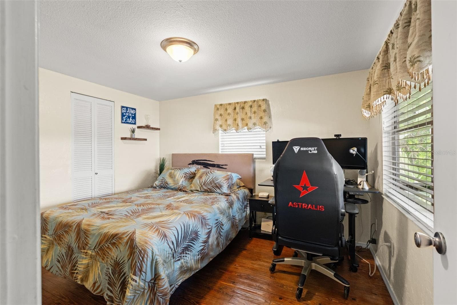 Warm wood floors and a dramatic stone fireplace anchor this comfortable living space. The open arrangement connects the living room with the dining area and kitchen, while sliding glass doors provide access to the screened porch. - 13 FRESHWATER, PALM HARBOR