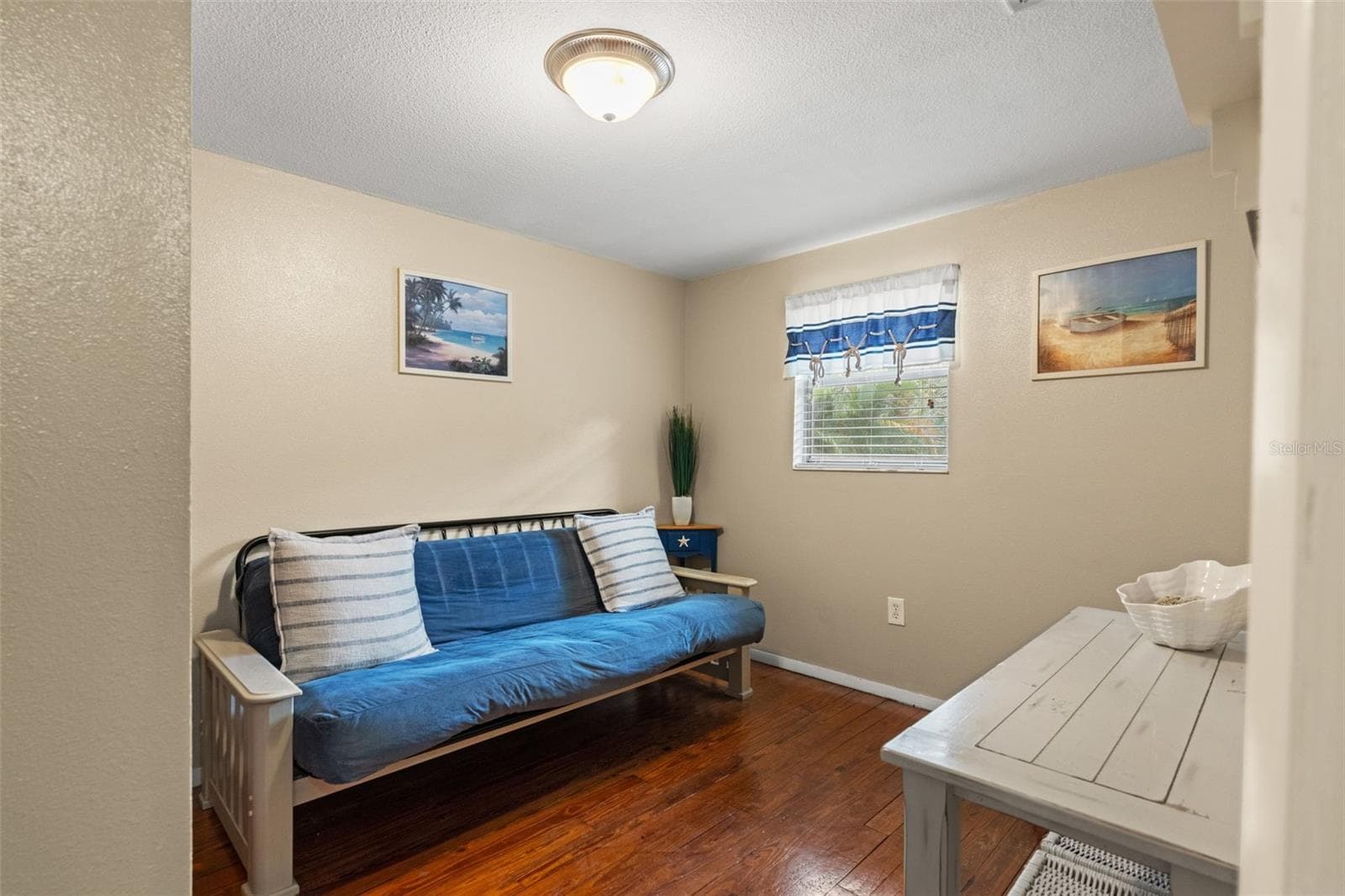Need a home office, guest room, or quiet retreat? This versatile room features wood flooring, natural light, and space for a variety of furniture arrangements. Currently furnished with a futon, it offers flexibility to suit your needs. - 13 FRESHWATER, PALM HARBOR