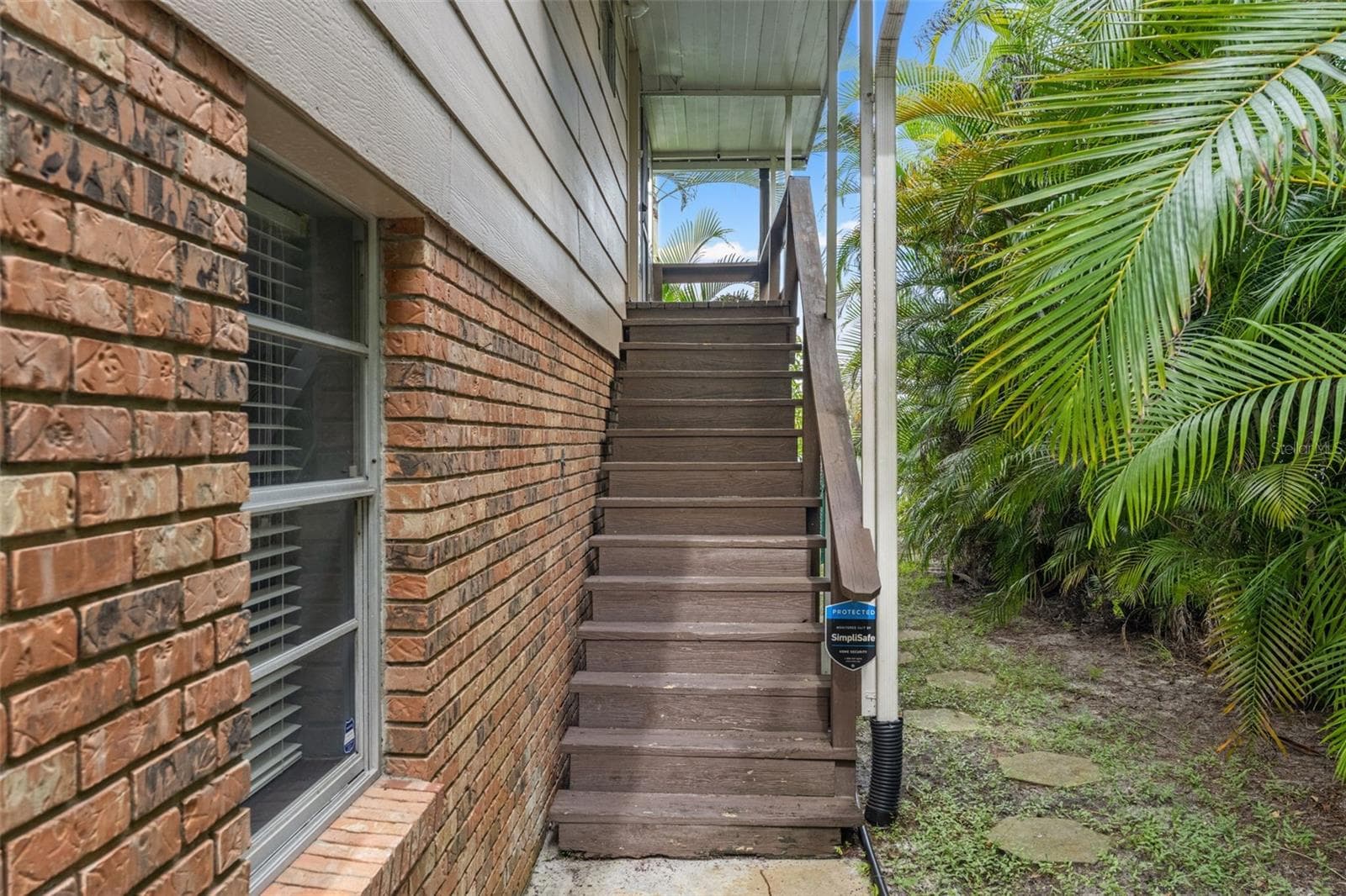A private exterior staircase leads to the upper-level entrance, providing convenient access to the main living area while preserving the home's distinctive elevated design. - 13 FRESHWATER, PALM HARBOR