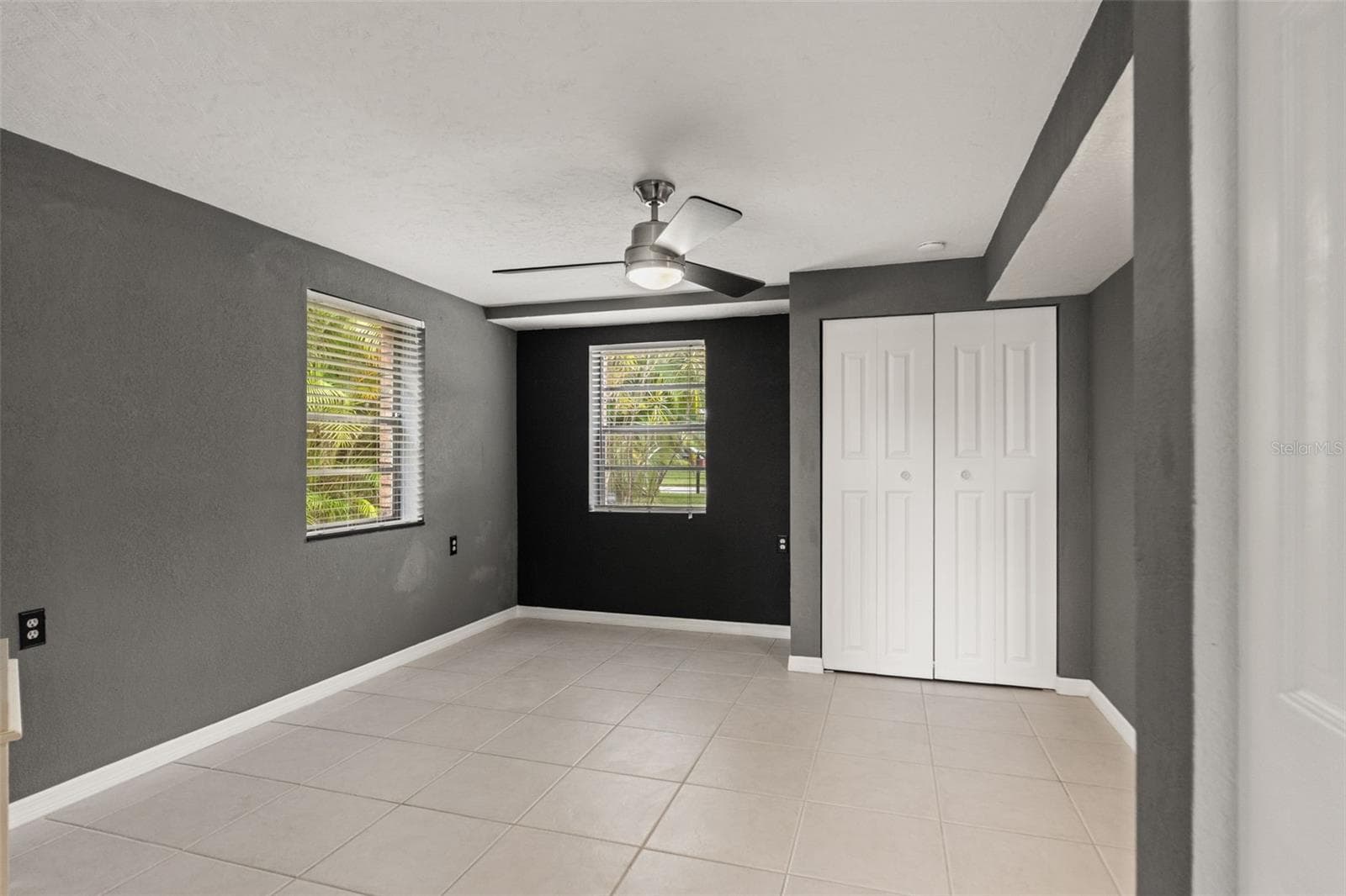 This separate downstairs room features neutral tile flooring, contemporary ceiling fan, two windows, and a closet. Its flexible layout provides options for a home office, hobby room, or additional guest space, depending on your needs. - 13 FRESHWATER, PALM HARBOR