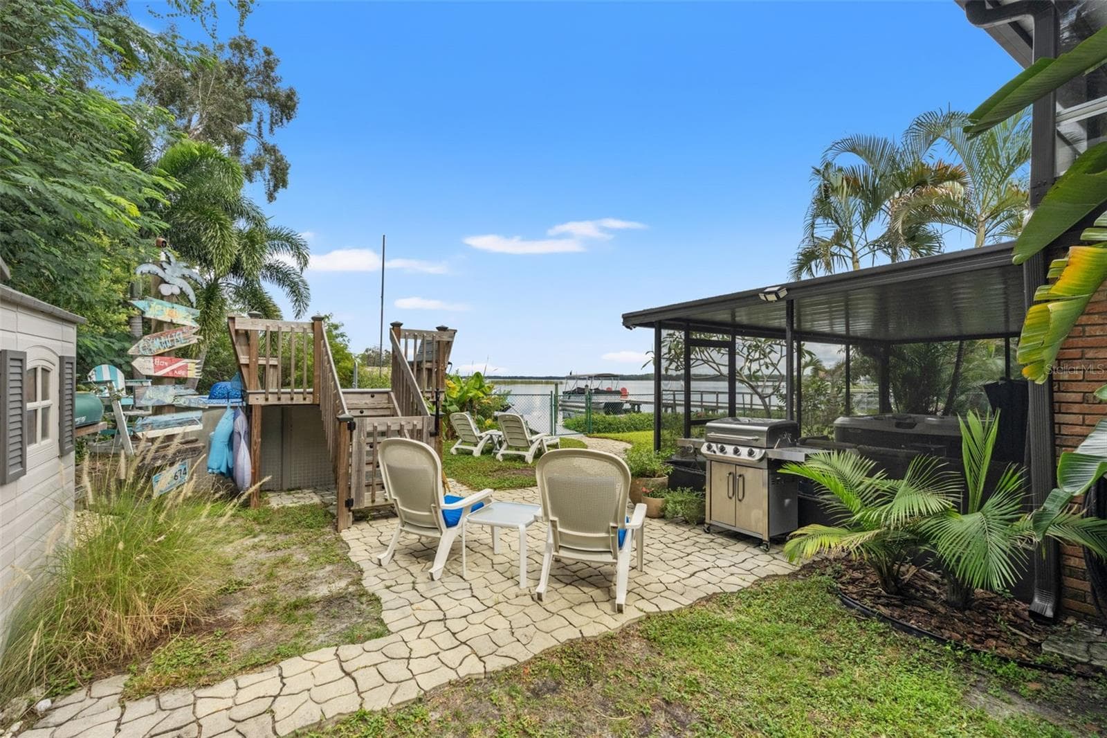 There's plenty of room to enjoy the Florida lifestyle! This backyard gathering area features a paver patio, grilling station, lounge seating, and an above-ground pool with a raised deck. Just beyond, the waterfront and dock create a beautiful backdrop for outdoor entertaining. - 13 FRESHWATER, PALM HARBOR