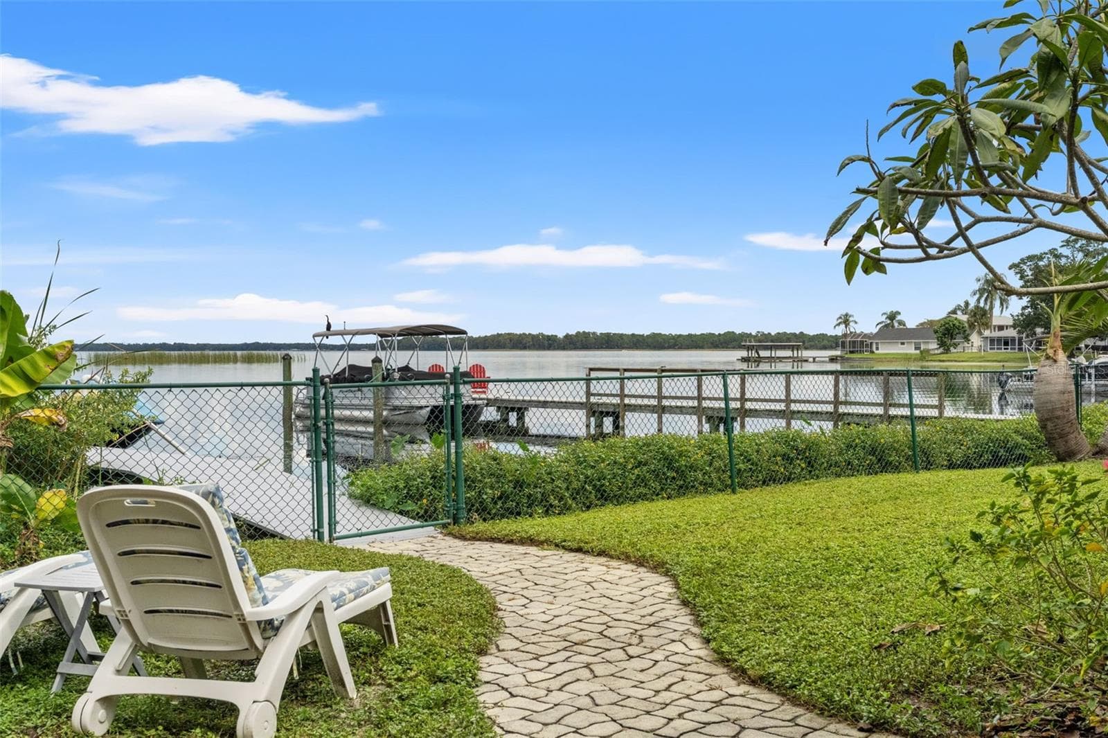 Imagine starting your morning with coffee overlooking the water or spending a quiet afternoon watching boats pass by. This backyard seating area offers beautiful lake views, with a private dock and convenient waterfront access just beyond the gate. - 13 FRESHWATER, PALM HARBOR