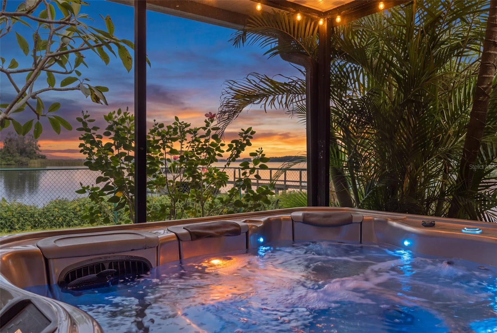 Imagine soaking in the hot tub as the sun sets over the water! Tropical palms provide a sense of privacy, while the screened enclosure lets you enjoy the outdoors in comfort. A beautiful setting to unwind at the end of the day. - 13 FRESHWATER, PALM HARBOR