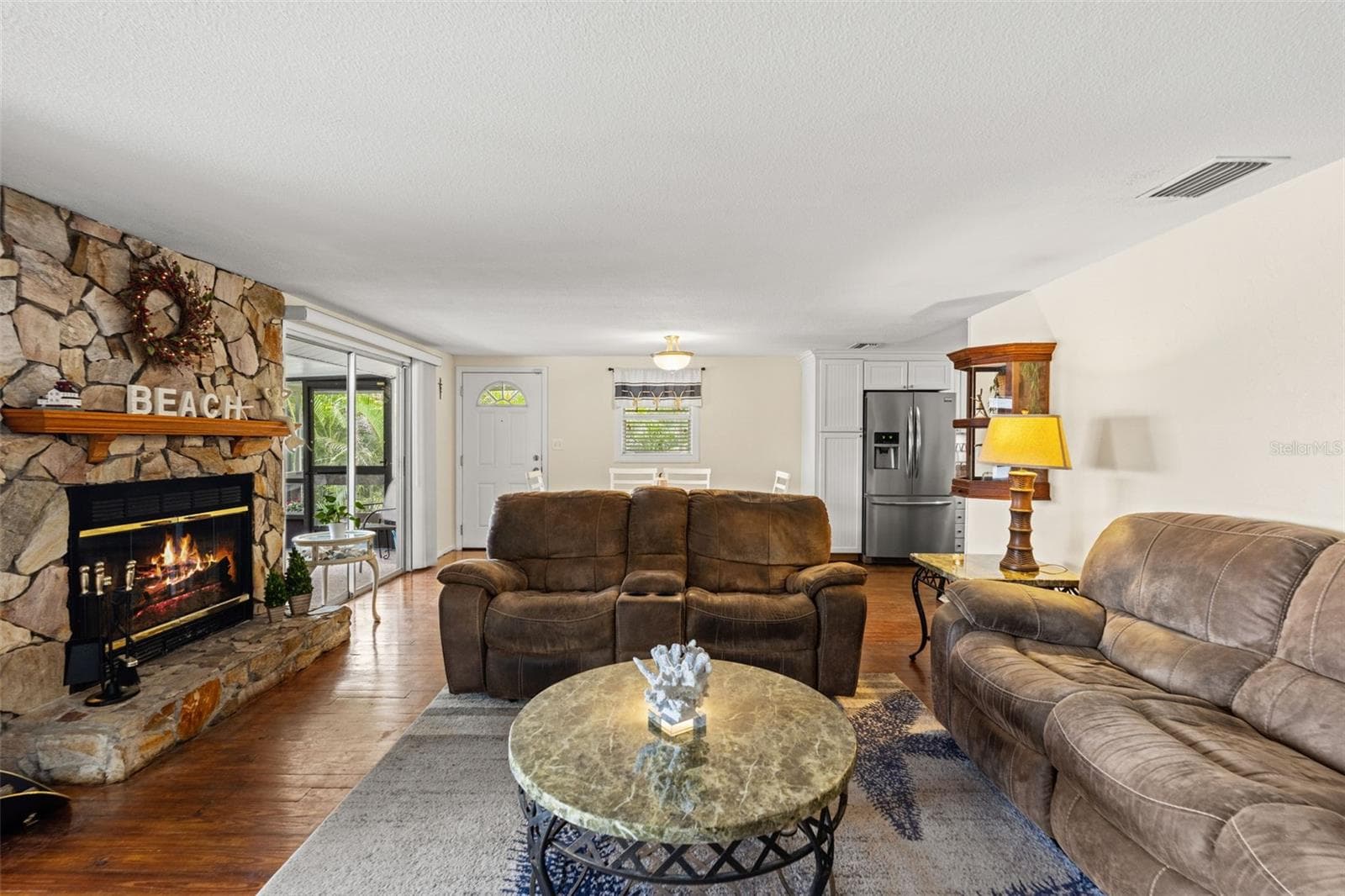 This is what waterfront living is all about! Sliding glass doors frame views of the screened porch, where a rocking chair invites you to sit back and enjoy the peaceful water, passing boats, and tropical surroundings. - 13 FRESHWATER, PALM HARBOR