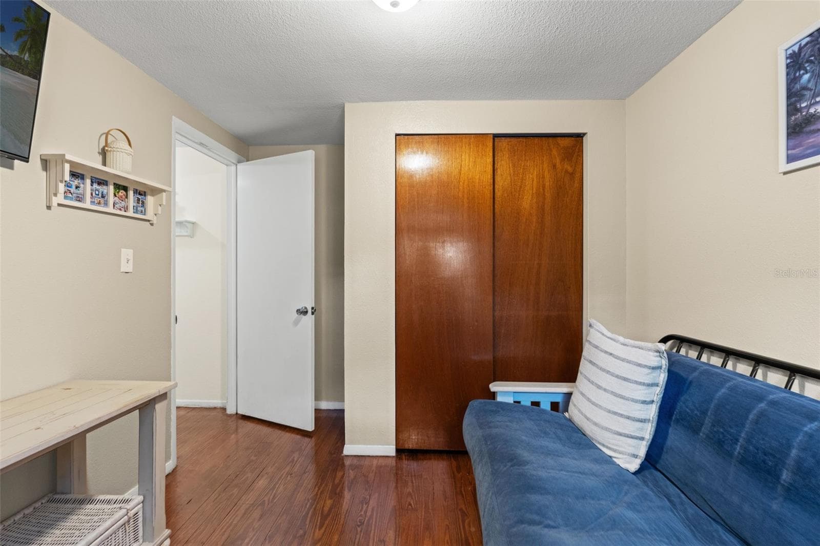 A second view of this versatile room highlights the built-in closet and warm wood flooring. Whether used for guests, hobbies, or a home office, this additional space offers practical flexibility. - 13 FRESHWATER, PALM HARBOR