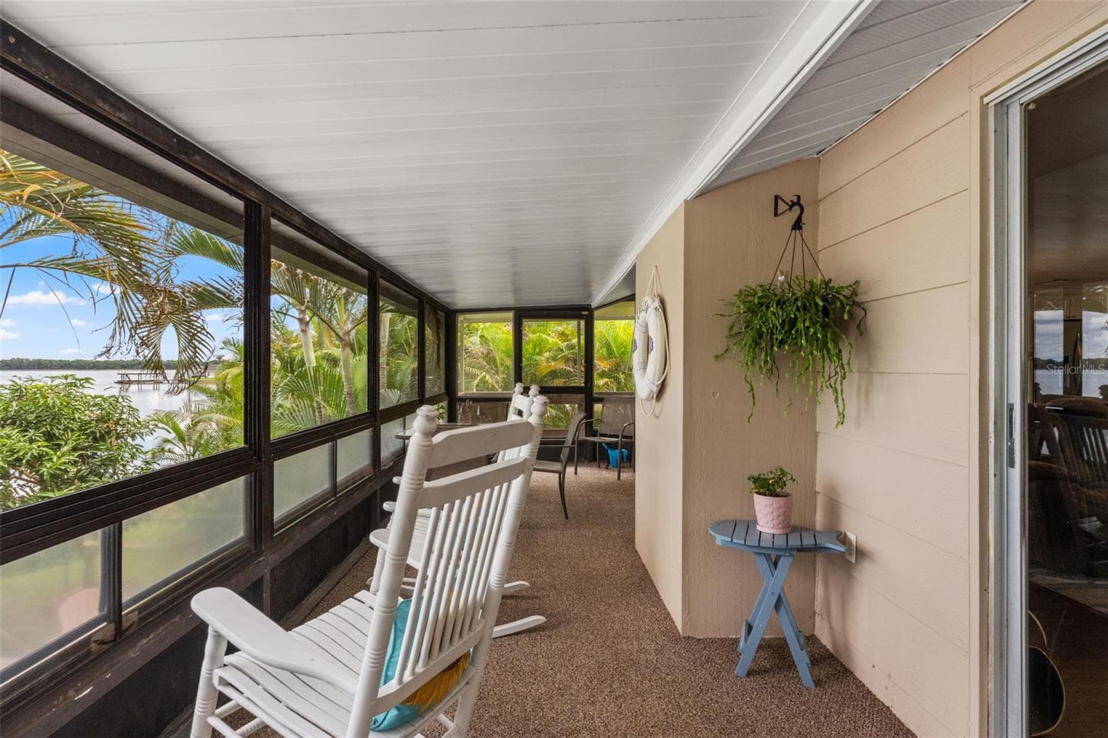 Water views, tropical landscaping, and a comfortable rocking chair create the perfect setting to unwind. This elevated screened porch offers a wonderful vantage point for watching boats on the water or simply enjoying the peaceful surroundings. - 13 FRESHWATER, PALM HARBOR
