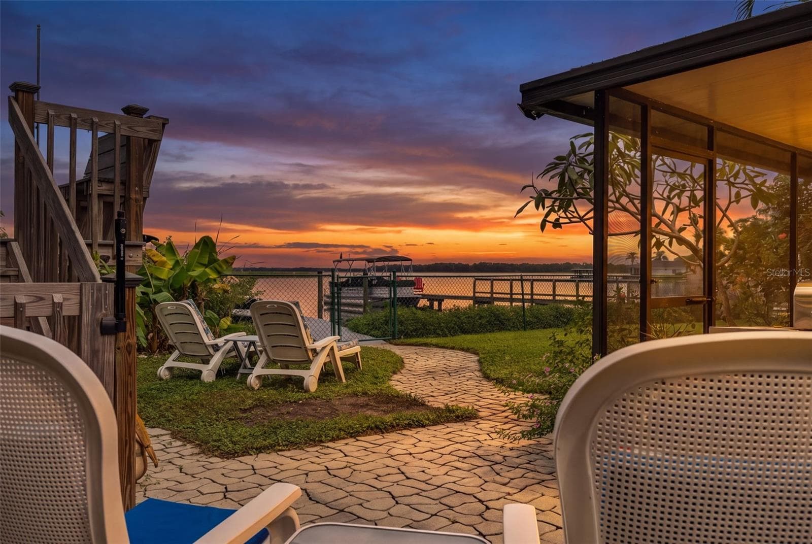 Imagine ending your day with this view! Brilliant shades of orange, pink, and purple stretch across the sky as the sun sets over the water. From the backyard patio, enjoy the peaceful waterfront setting, tropical landscaping, and the private dock just steps away. This is what Florida waterfront living is all about. - 13 FRESHWATER, PALM HARBOR
