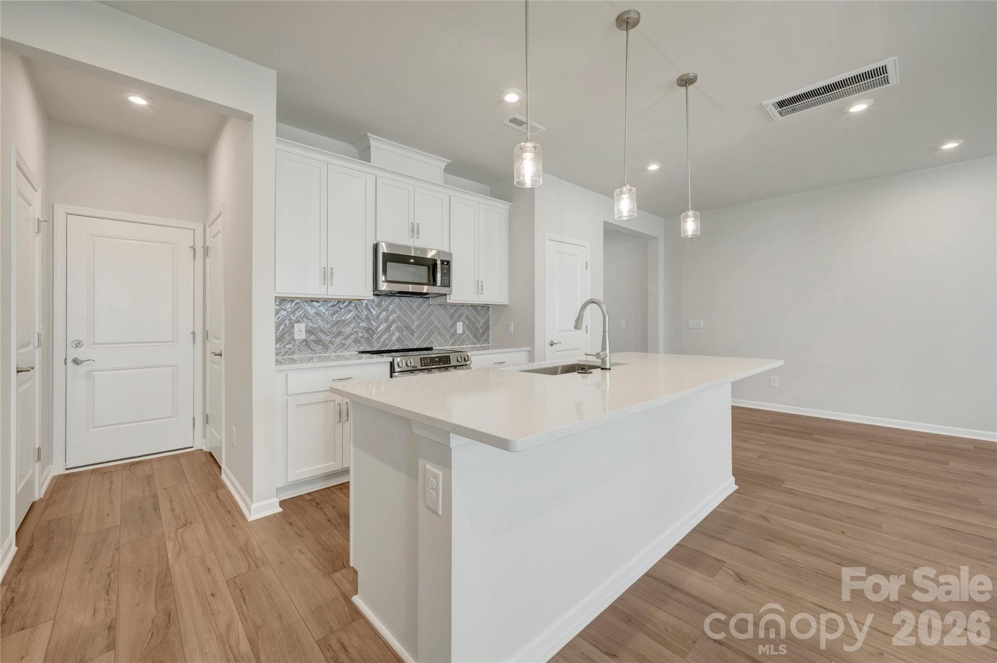 Kitchen with white cabinets and white quartz countertops - 709 Bowery Place, Cramerton