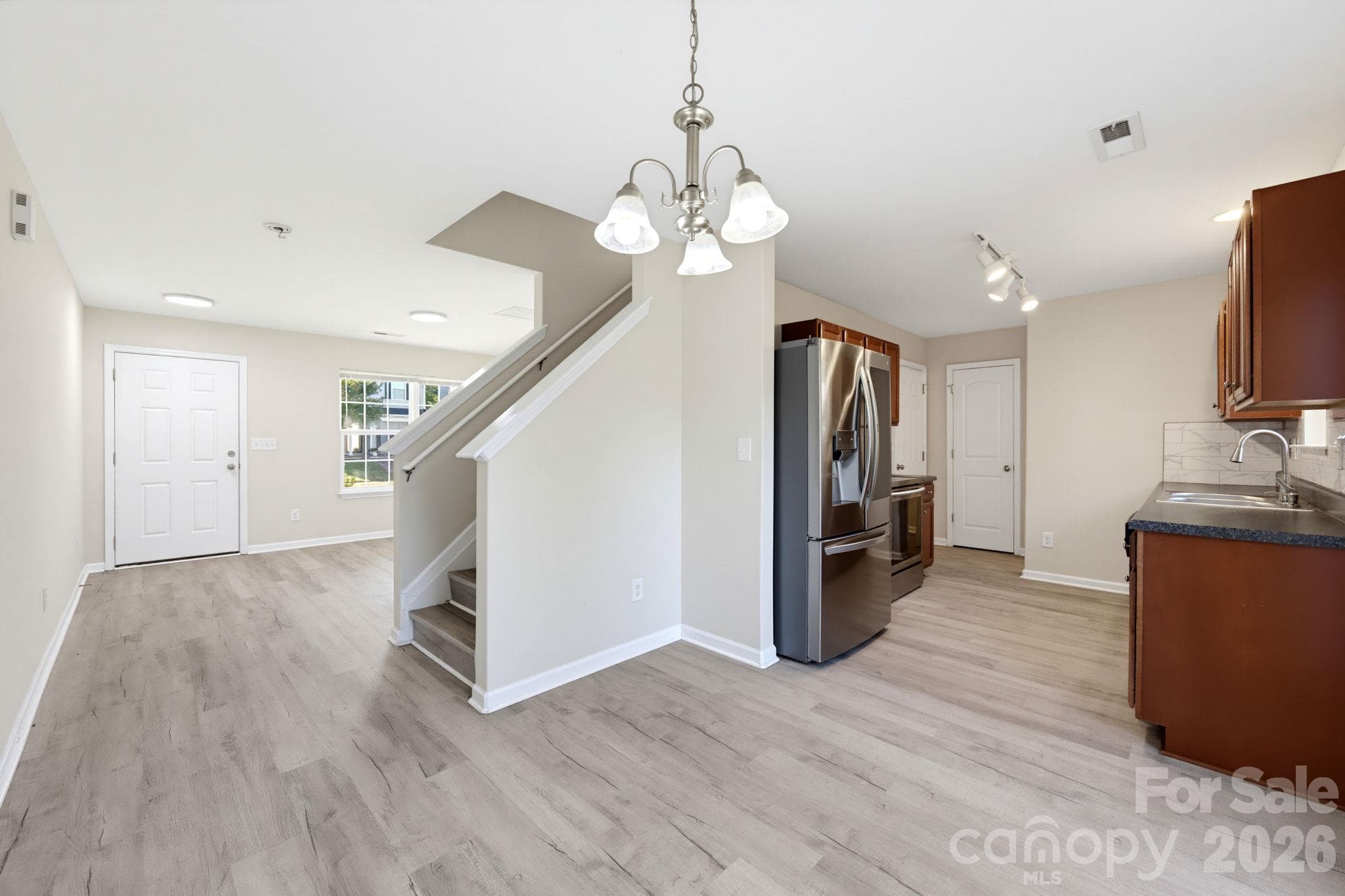 Open layout connecting the living area and kitchen, creating a comfortable space for everyday living and entertaining. - 5718 Natick Drive, Charlotte