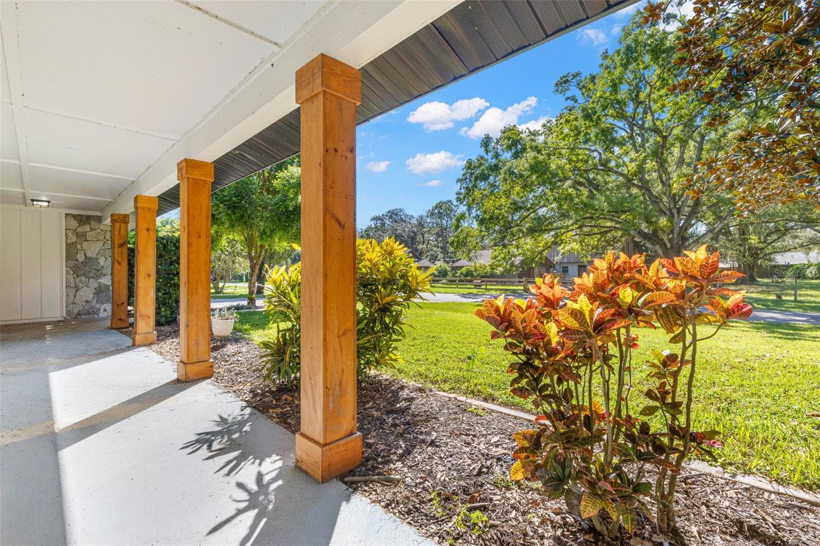 The expansive covered front porch offers a shaded spot to relax, enjoy your morning coffee, or unwind while overlooking the beautifully landscaped front lawn and mature shade trees. - 3013 GRAHAM LN, TAMPA