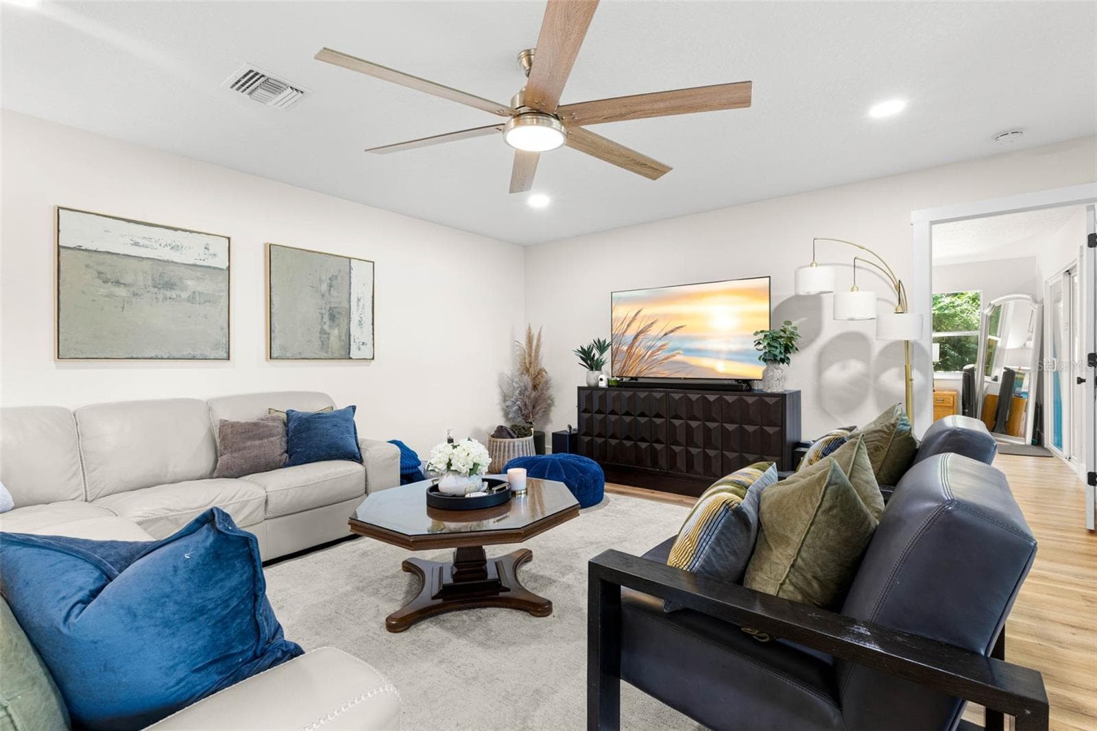 Another perspective of the spacious living room highlights its comfortable layout, generous seating area, recessed lighting, and contemporary ceiling fan with wood-tone blades. An inviting space for relaxing with family or entertaining guests. - 3013 GRAHAM LN, TAMPA