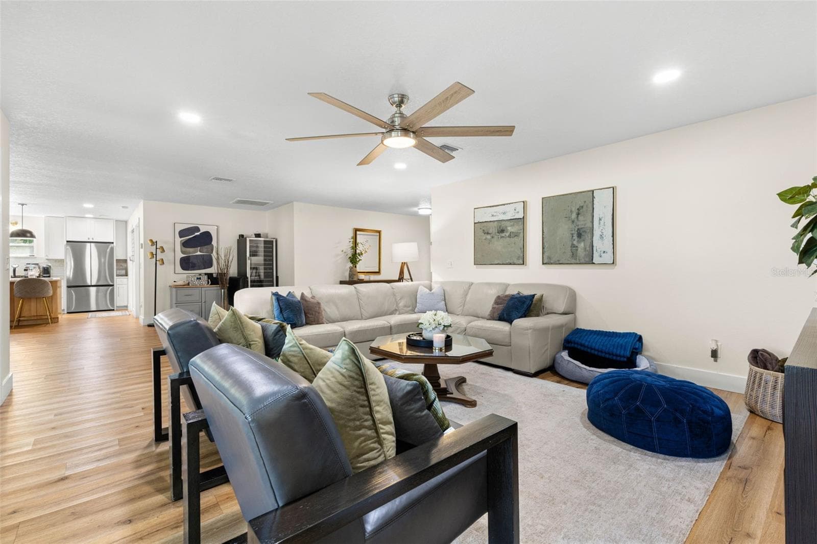 The open-concept floor plan creates an effortless flow between the generously proportioned living room and kitchen. Continuous wood-look luxury vinyl flooring, neutral finishes, and recessed lighting bring warmth and continuity to the main living areas. - 3013 GRAHAM LN, TAMPA