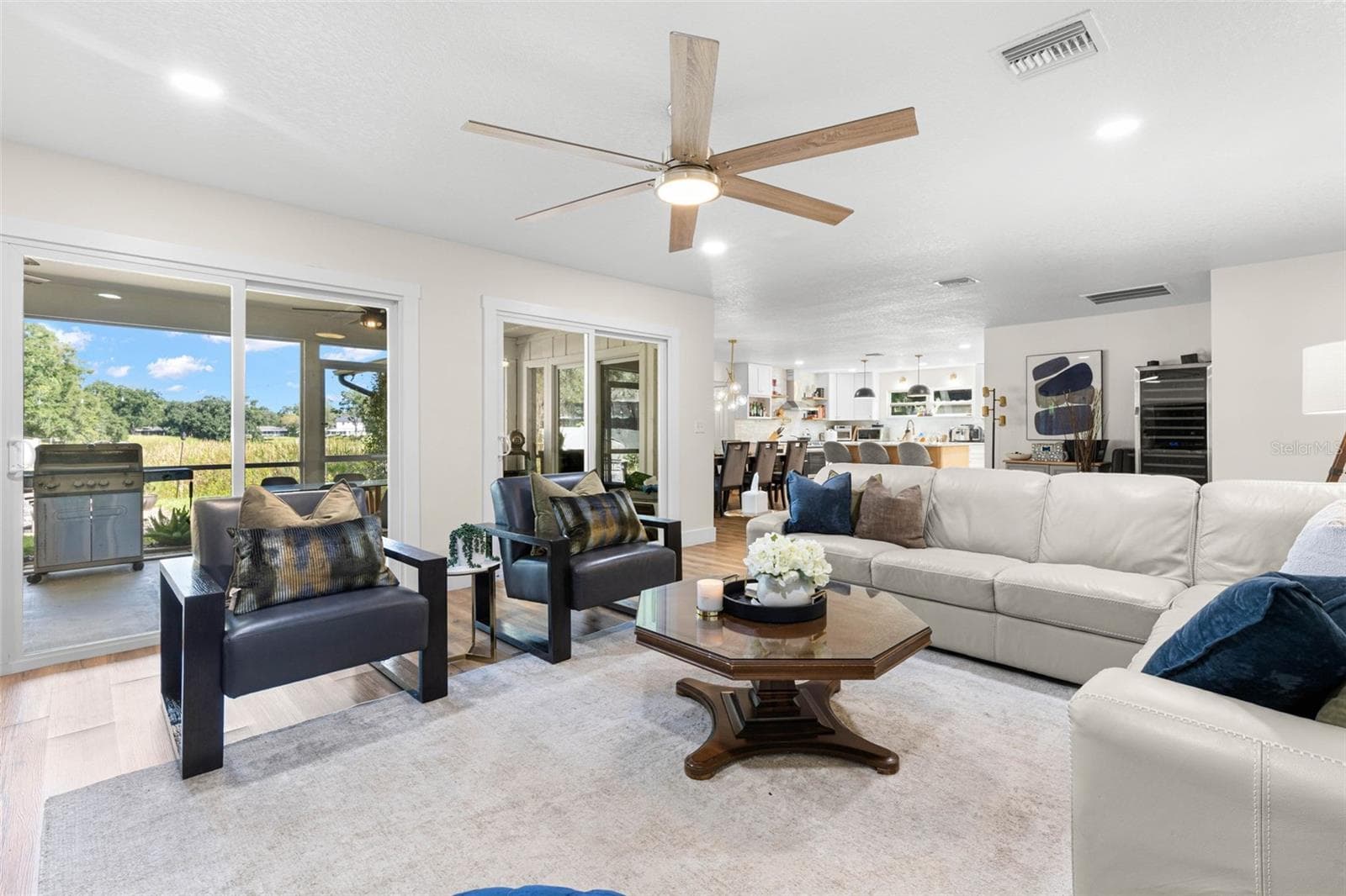 Natural light pours into the living room through sliding glass doors overlooking the backyard, while the open floor plan provides an easy connection to the dining area and kitchen. Step outside to the screened porch for an effortless extension of your indoor living space. - 3013 GRAHAM LN, TAMPA