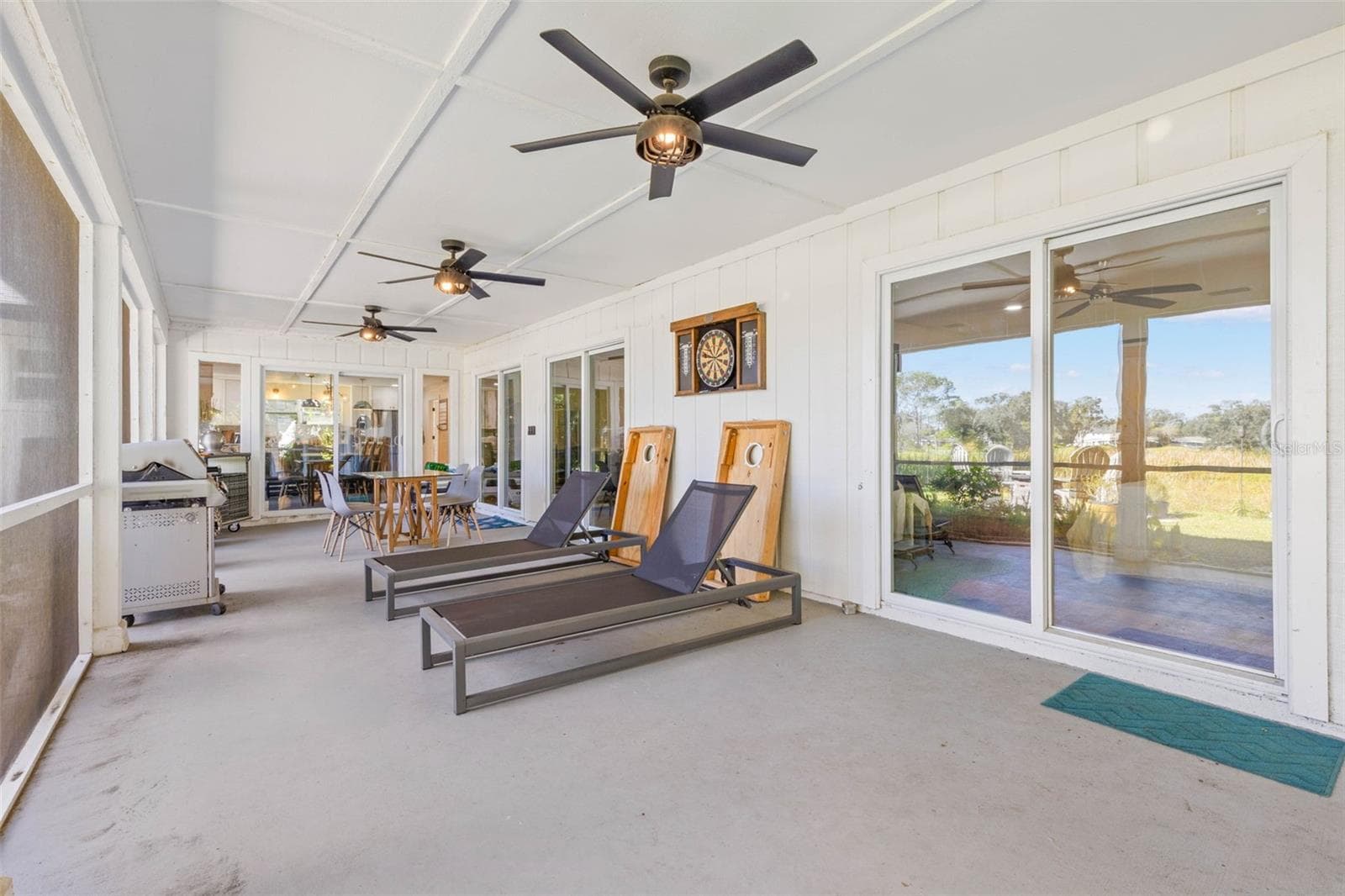 An impressive screened porch extends across the back of the home, offering plenty of room for outdoor dining, lounging, and entertaining. Three ceiling fans provide added comfort, while multiple sliding glass doors connect this versatile retreat to the interior living spaces. - 3013 GRAHAM LN, TAMPA