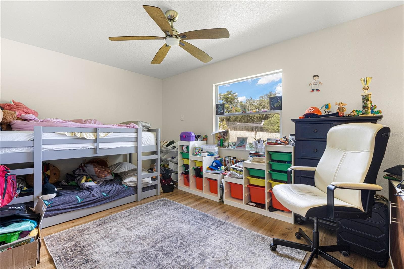 Bedroom two offers a comfortable layout with wood-look luxury vinyl flooring, a contemporary ceiling fan, and a large window that welcomes natural light. Easily adaptable as a guest bedroom, home office, or creative space to suit your needs. - 3013 GRAHAM LN, TAMPA