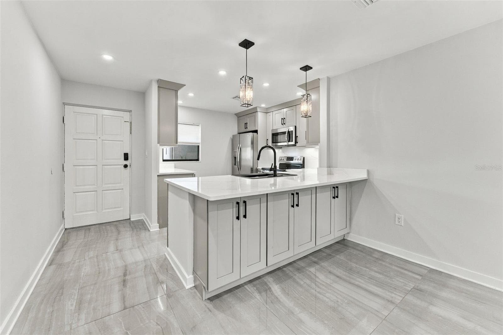 Front entry with the beautifully remodeled kitchen - 2650 COUNTRYSIDE BLVD #A306, CLEARWATER