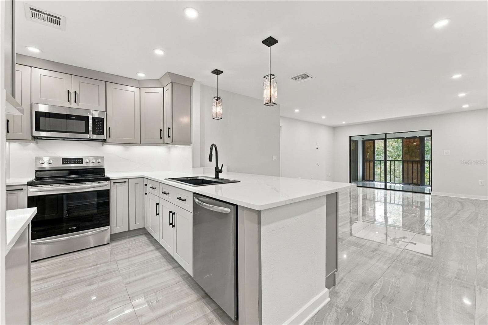 Beautiful kitchen featuring quartz countertops and matching backsplash - 2650 COUNTRYSIDE BLVD #A306, CLEARWATER