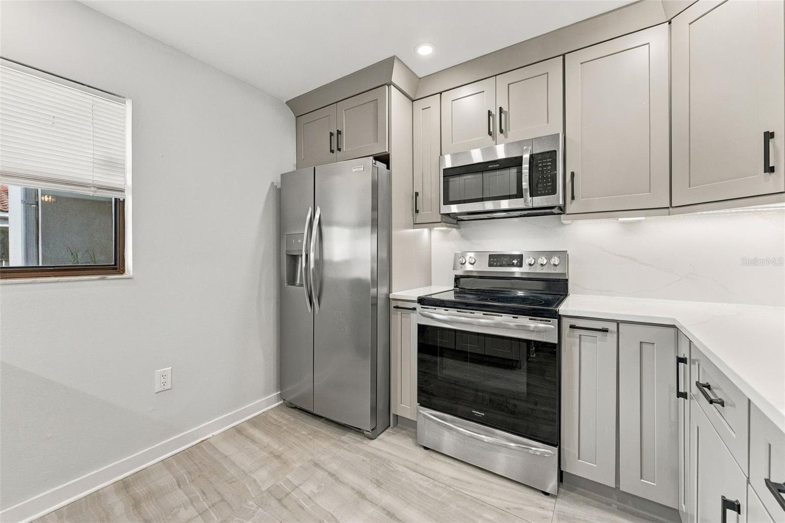 Updated kitchen with shaker-style cabinetry and new appliances - 2650 COUNTRYSIDE BLVD #A306, CLEARWATER